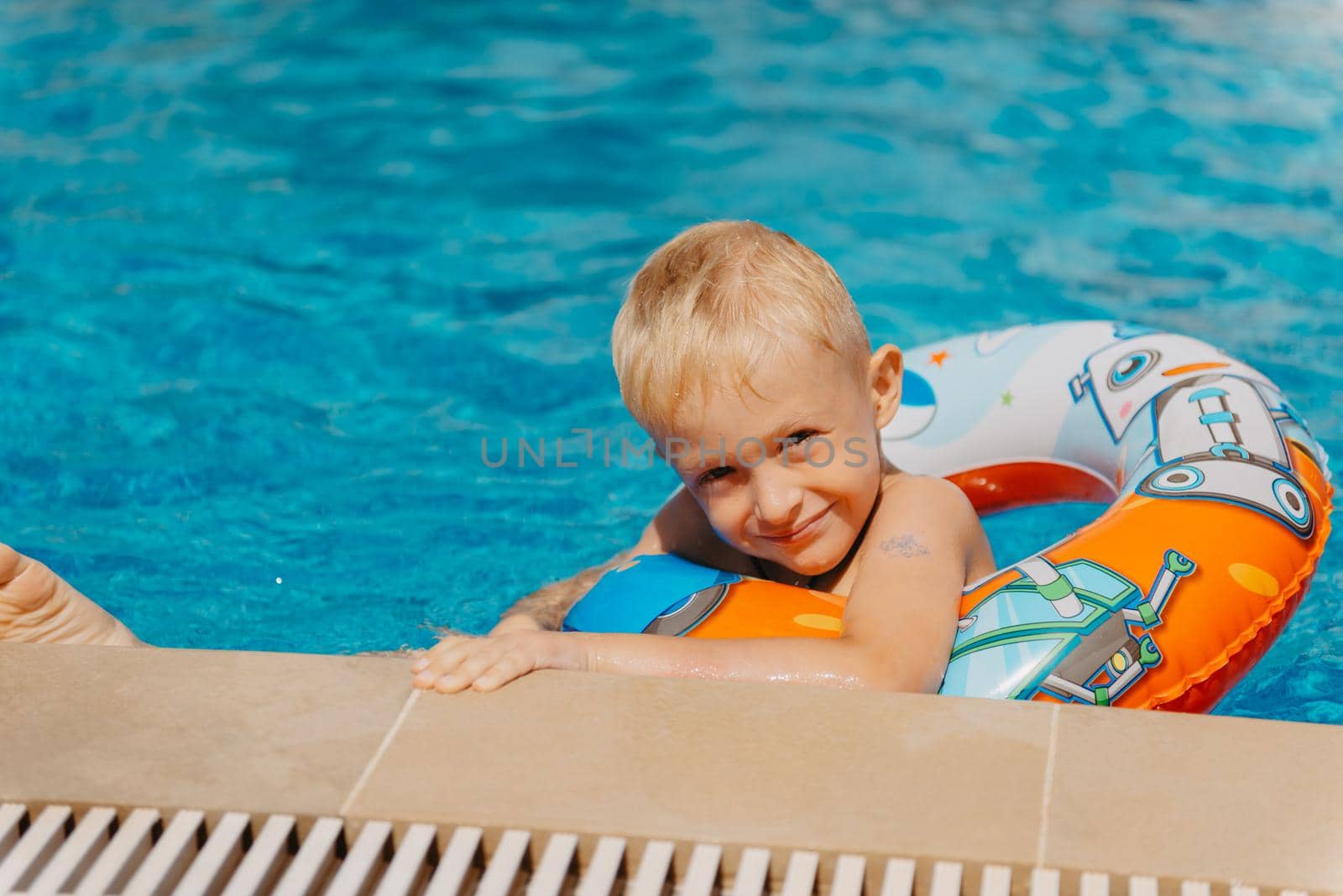 Happy child having fun on summer vacation. Kid playing with rubber duck and ball in the sea. Healthy lifestyle concept. Happy child playing in swimming pool. Summer vacations concept