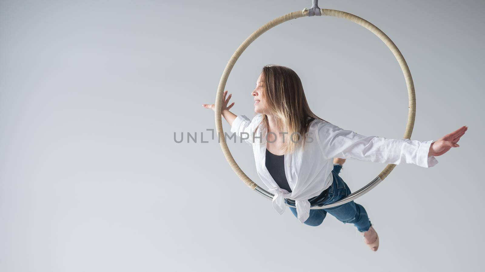 Caucasian woman in casual clothes and high heels shoes on air hoop