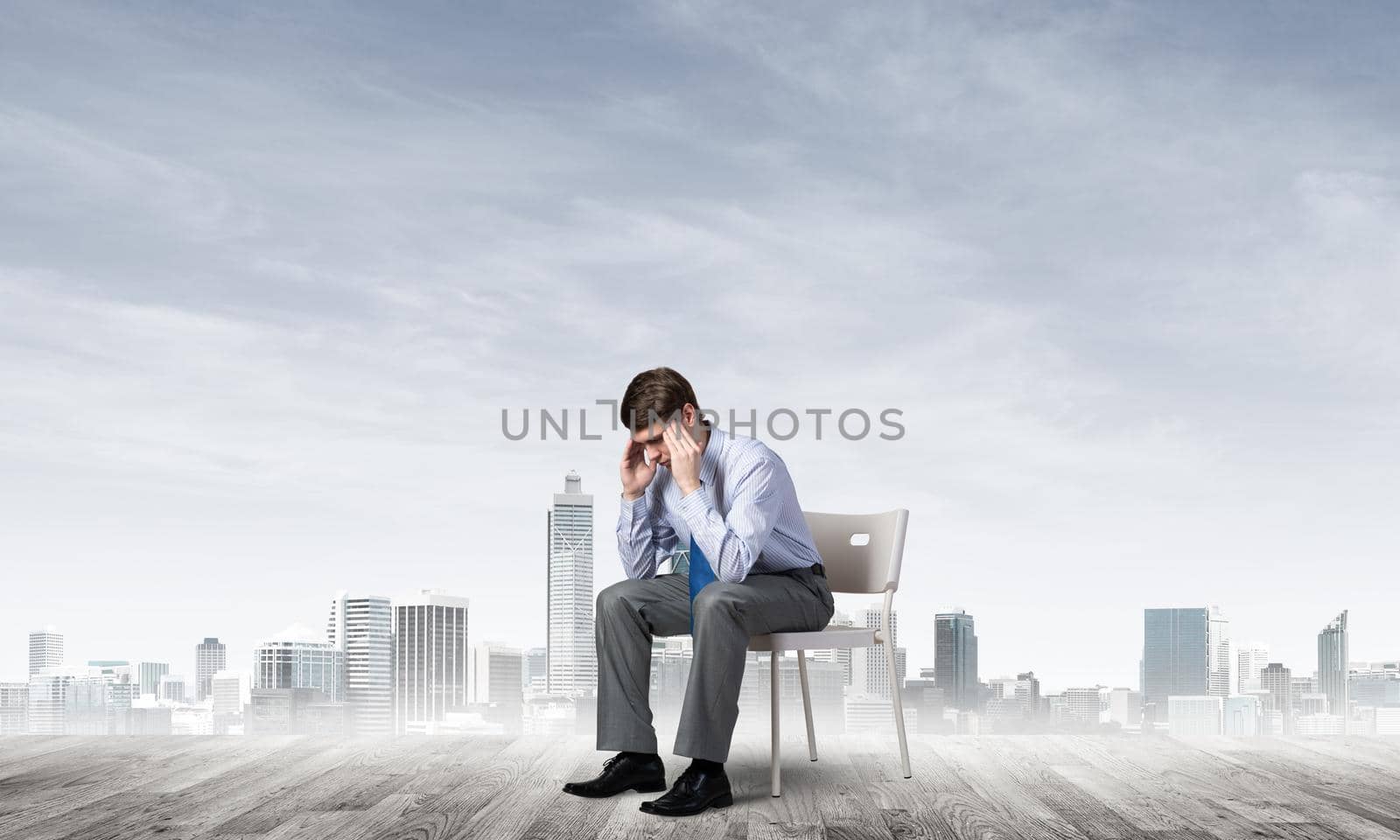 Businessman is sitting on an office chair with his head in his hands. Business stress and problems