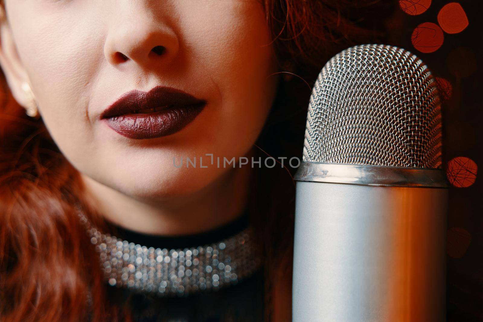 Female singer with disco mic on bokeh light background. by savconstantine