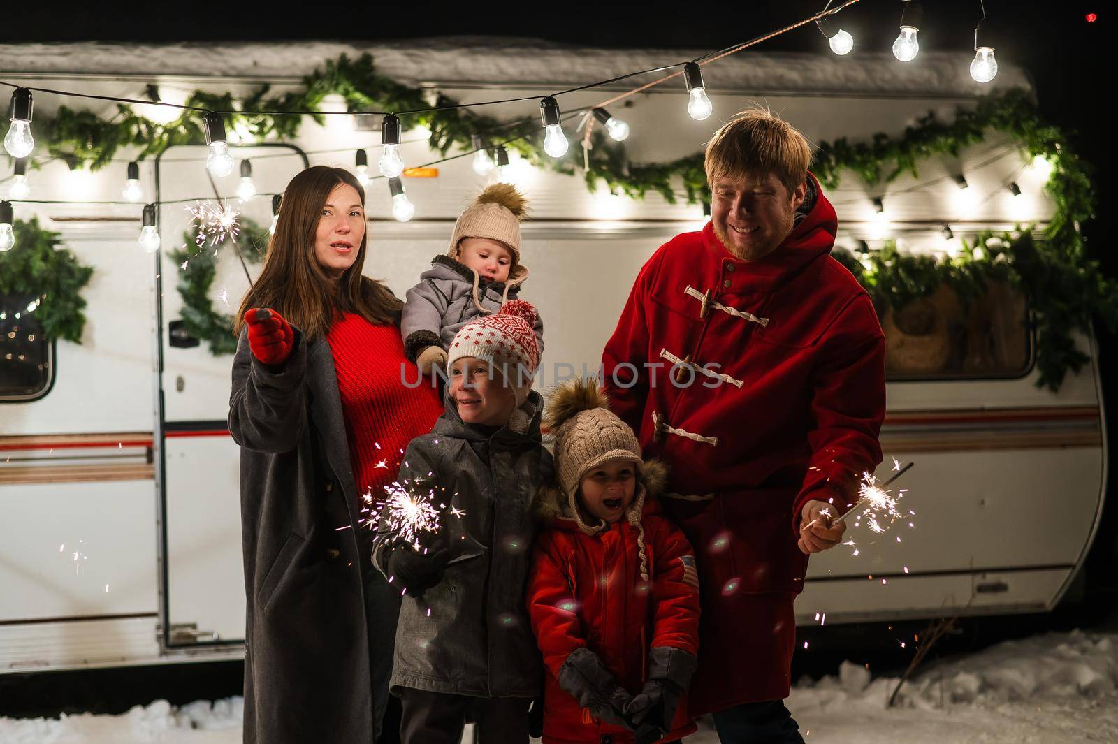 Happy parents with three sons celebrating christmas in motorhome