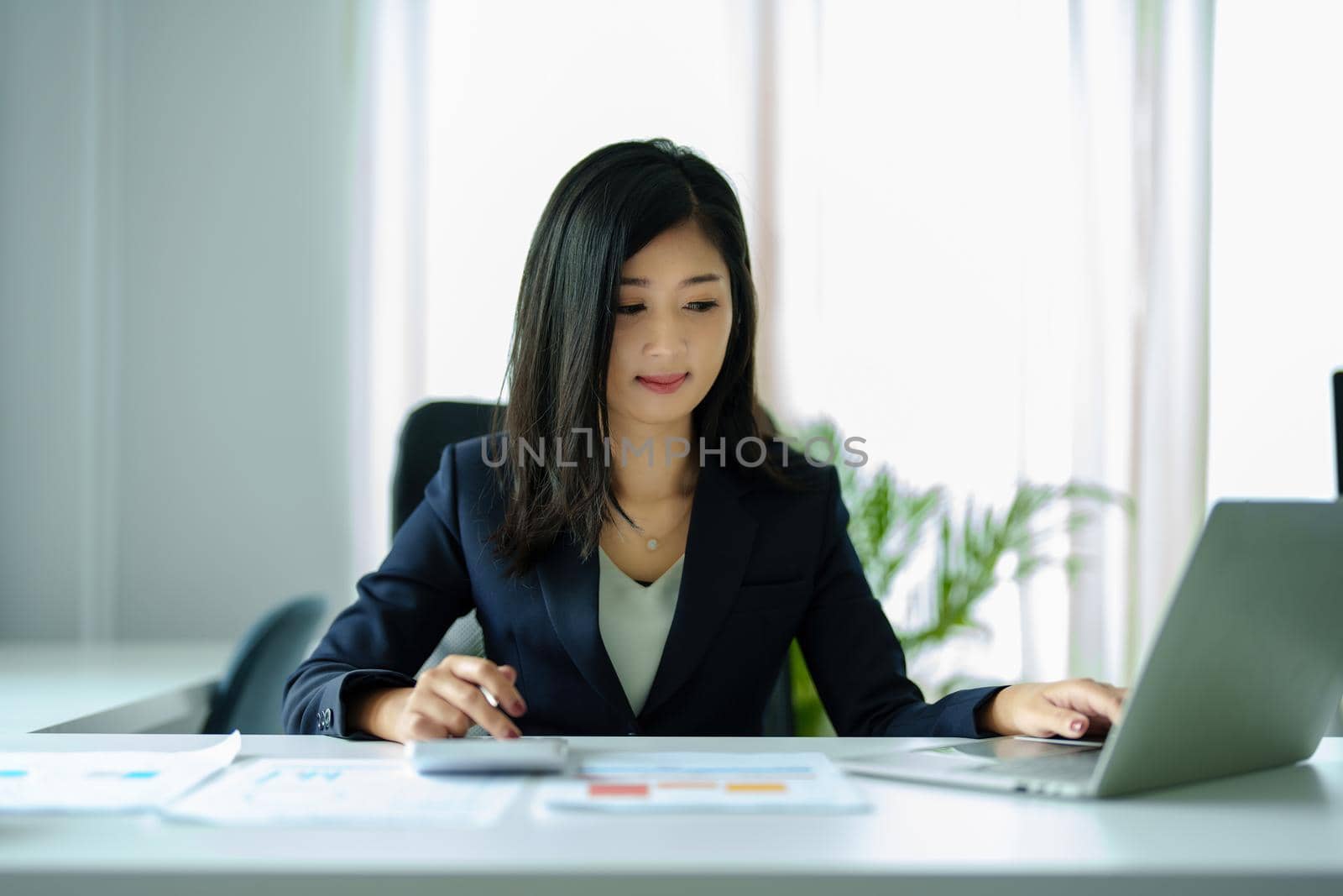 accountant, Auditor, Self-Employed, Finance and Investment, tax calculation and budget, Portrait of Asian female entrepreneur using a calculator to calculate. Company business results document