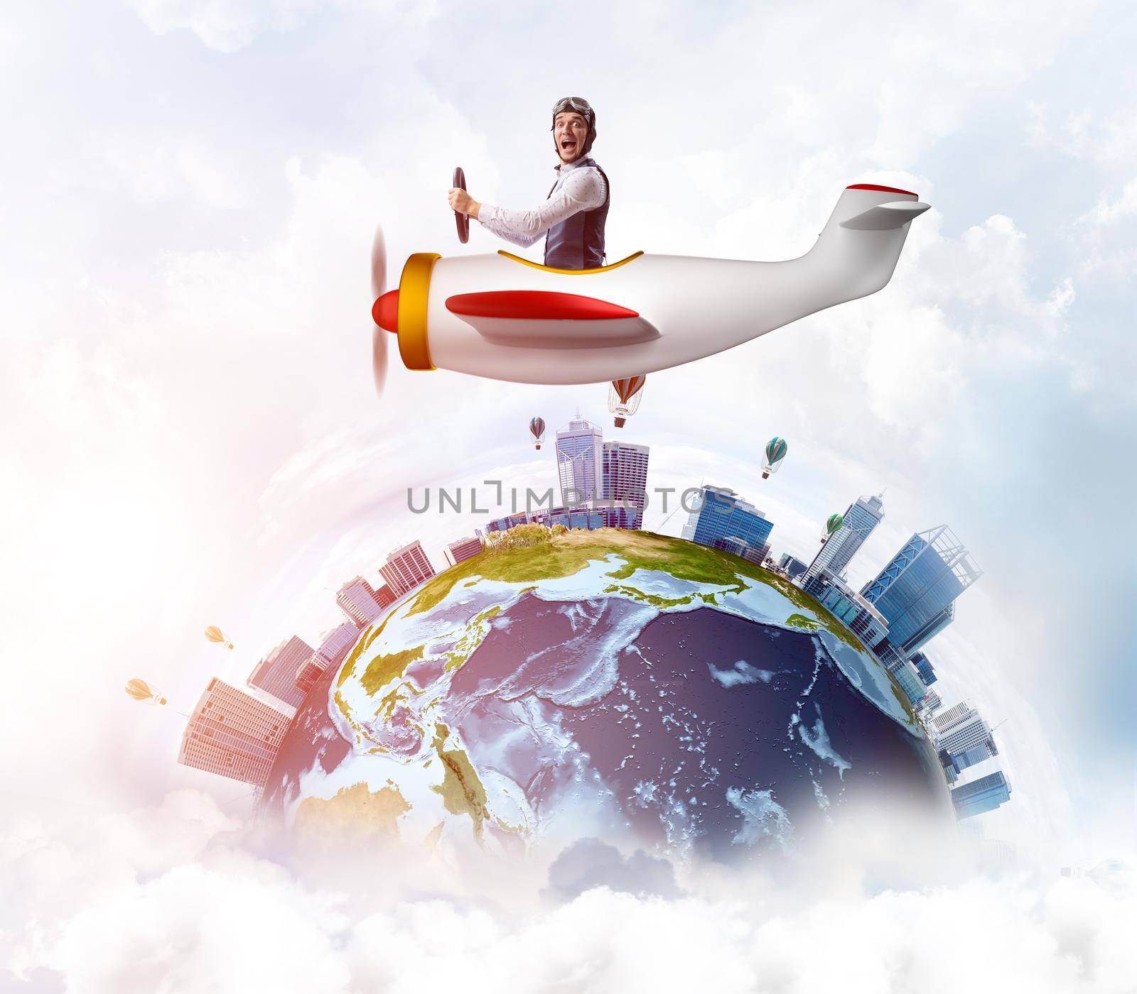 Businessman in aviator leather hat driving propeller plane. Traveling around the world by airplane. Funny man flying in small airplane in blue sky with clouds. Earth planet with modern cityscape.