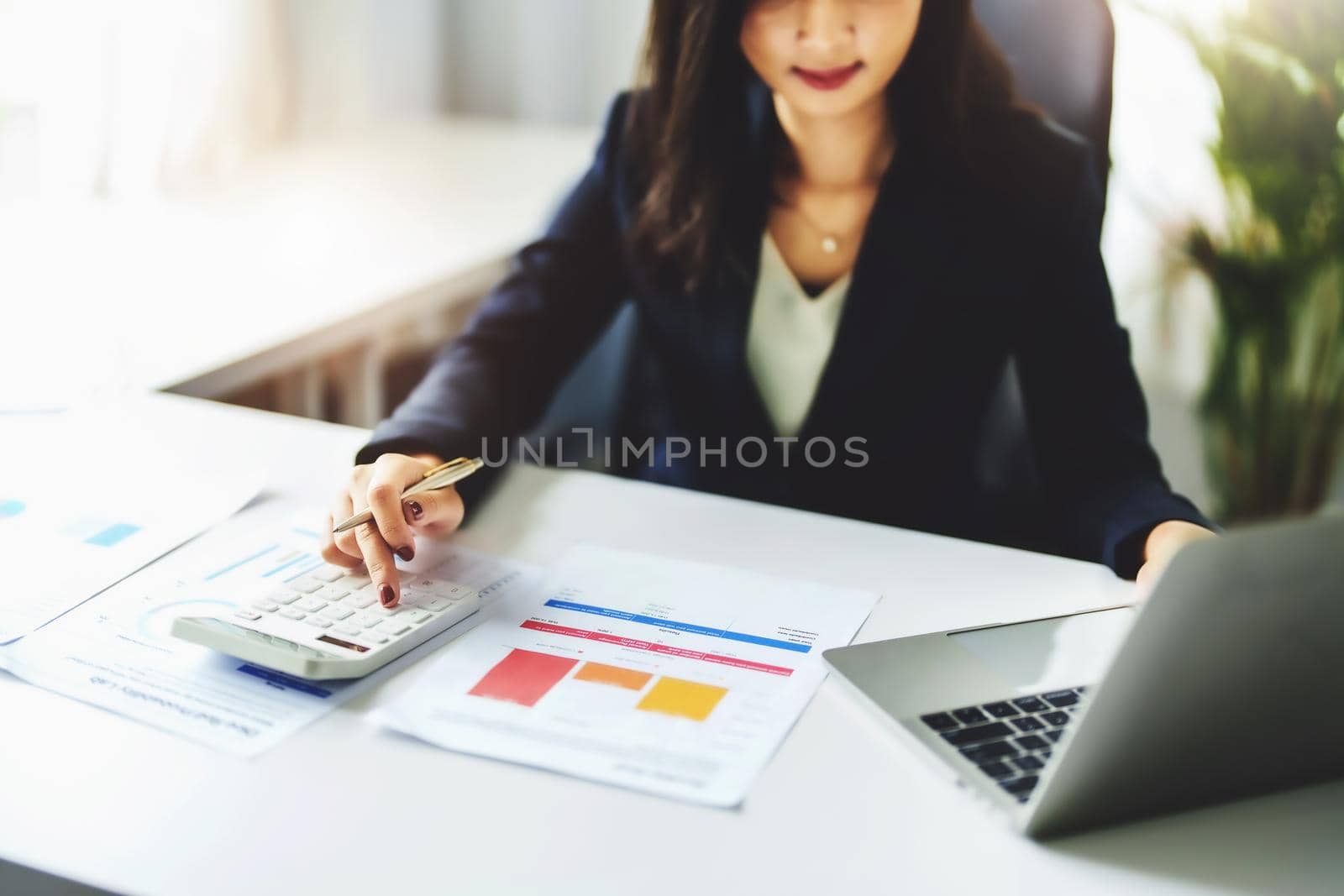 accountant, Auditor, Self-Employed, Finance and Investment, tax calculation and budget, Asian female entrepreneur using a calculator to calculate. Company business results document