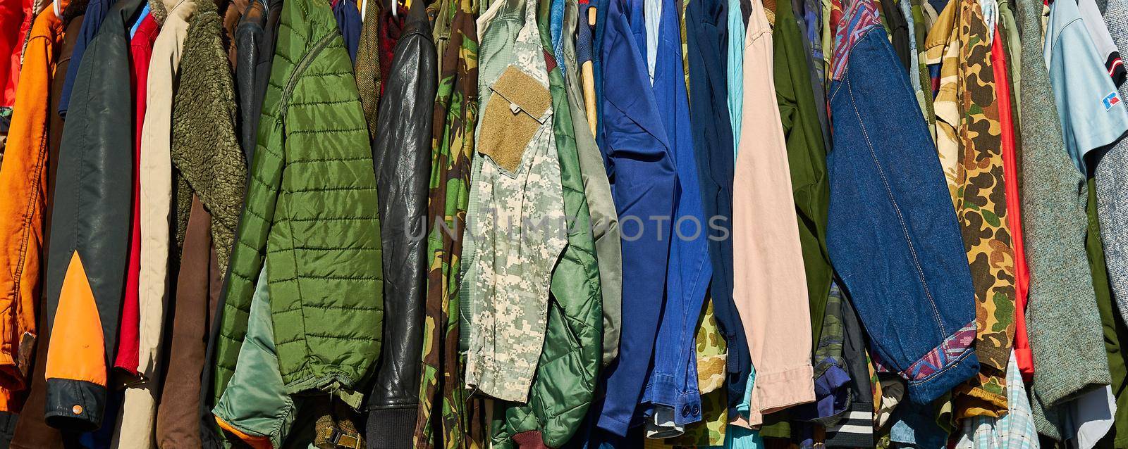 A row of jackets, coats and clothes of different colours, patterns and styles