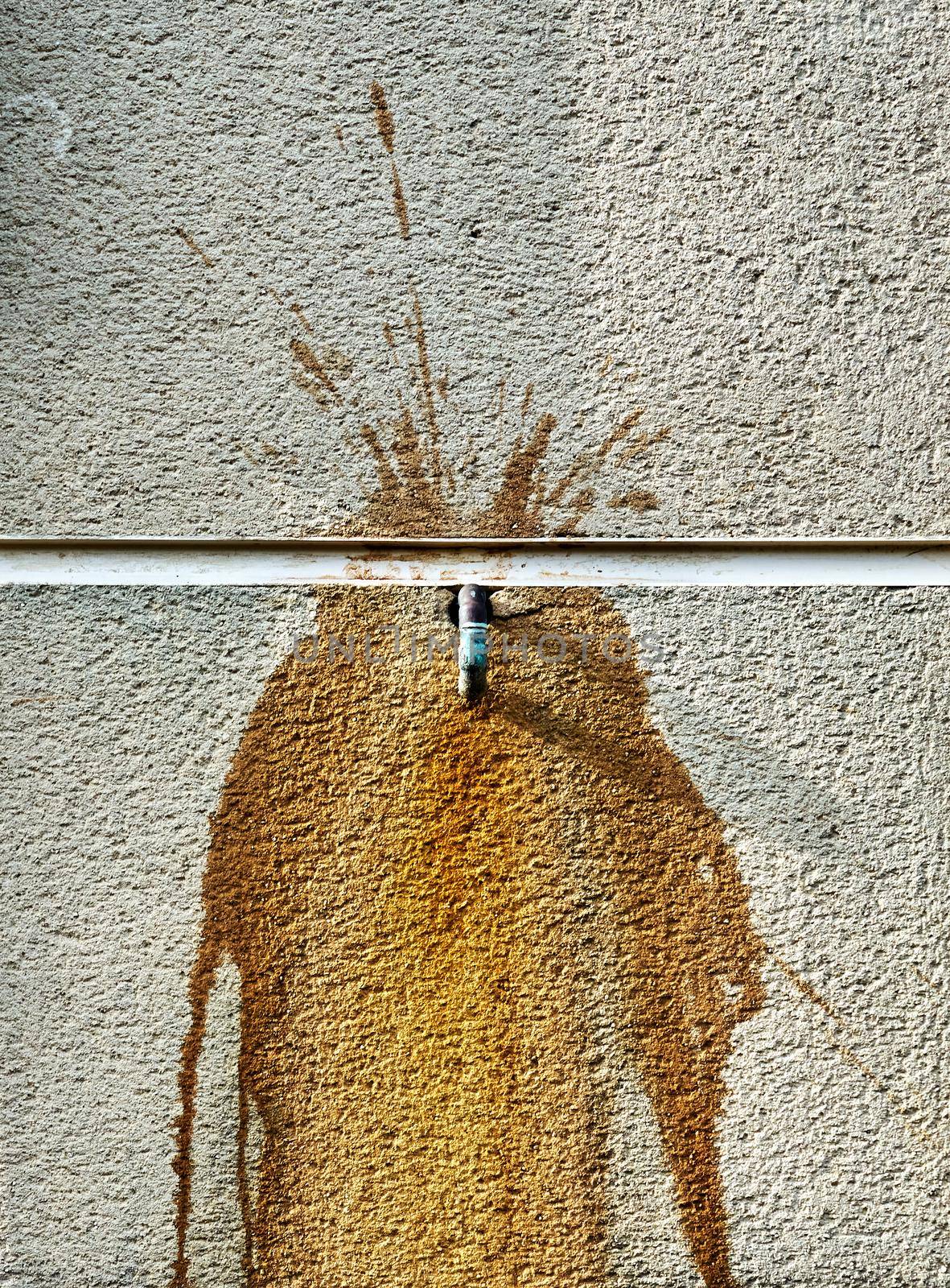 A copper pipe and rust on a concrete wall by ChrisWestPhoto