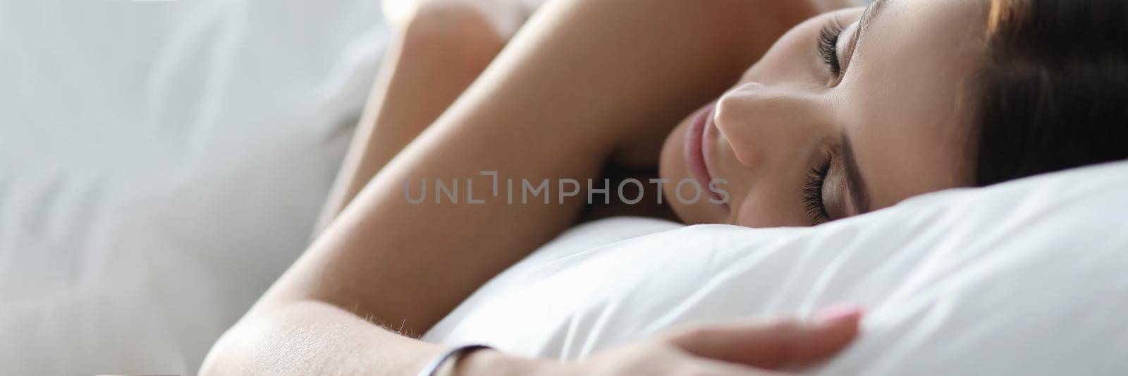 Nude woman sleeps calmly at home under covers. Young woman sleeping peacefully on white bedding. Relaxation and speedy falling asleep. Comfortable stay at home quarantine. Hypoallergenic bedding