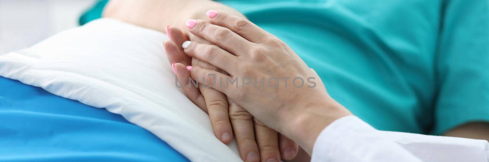 Doctors hands hold hands patient lying in ward. Treatment and prevention many diseases. Manifestations human attention to patients in serious condition. Highly qualified professional medical staff