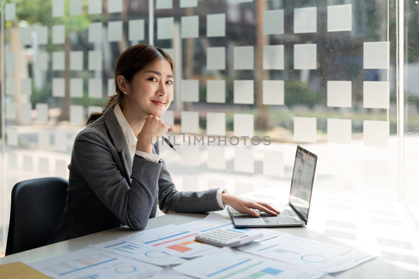 Portrait of attractive asian businesswoman working on laptop for marketing plan financing calculation concept