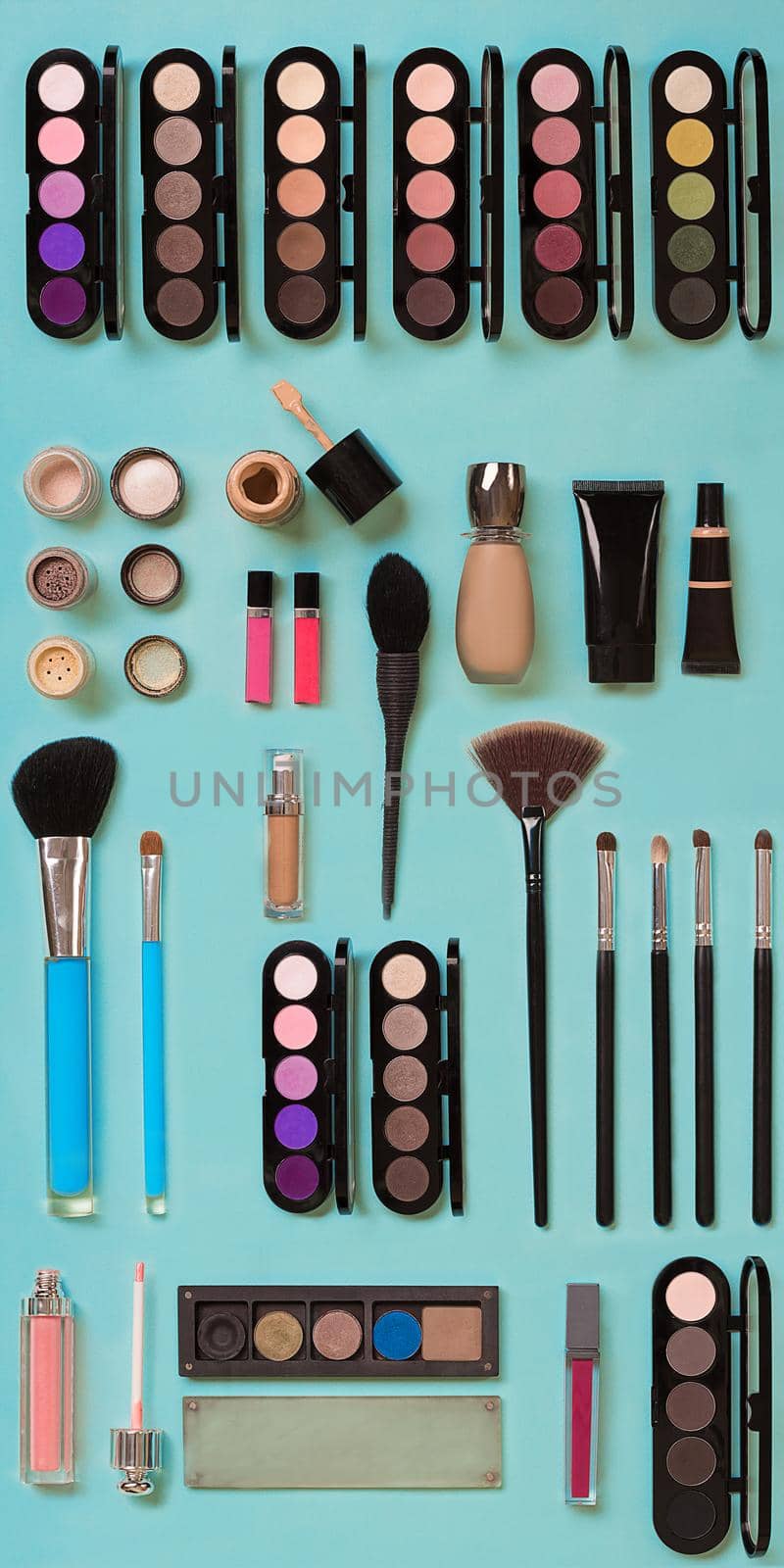 cosmetics for facial makeup: brushes, powder, lipstick, eye shadow, trimmer and other accessories on blue background top view. by nazarovsergey