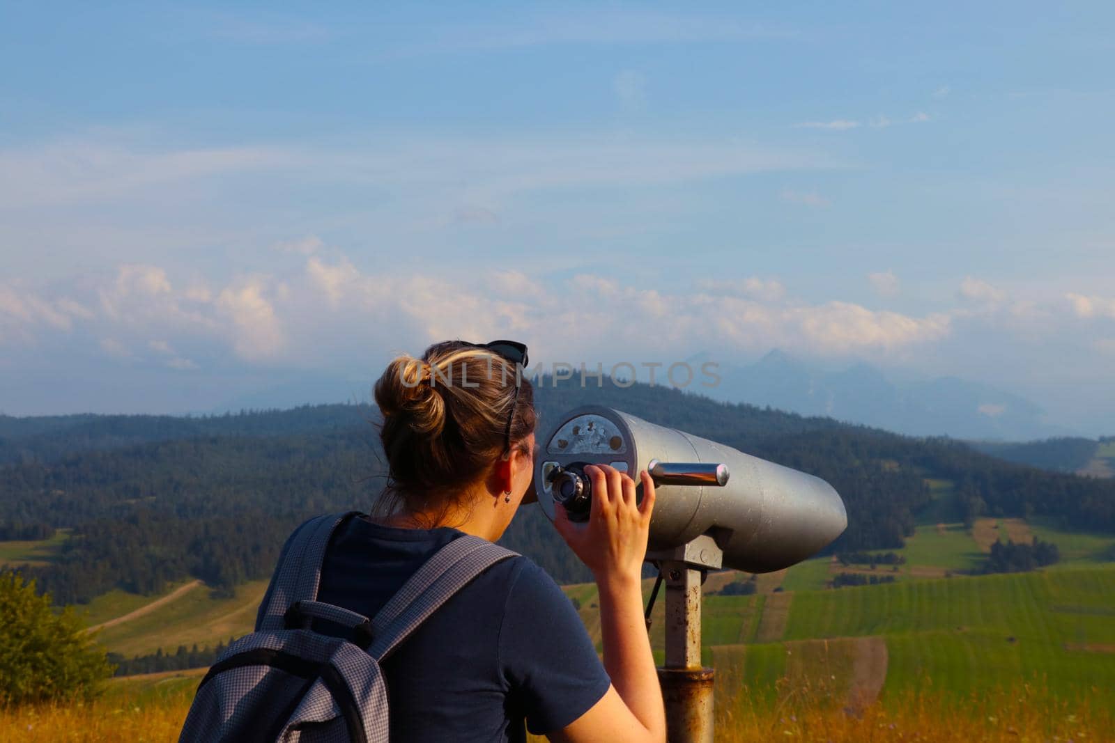 The traveler looks into the distance through binoculars. Mountain landscape