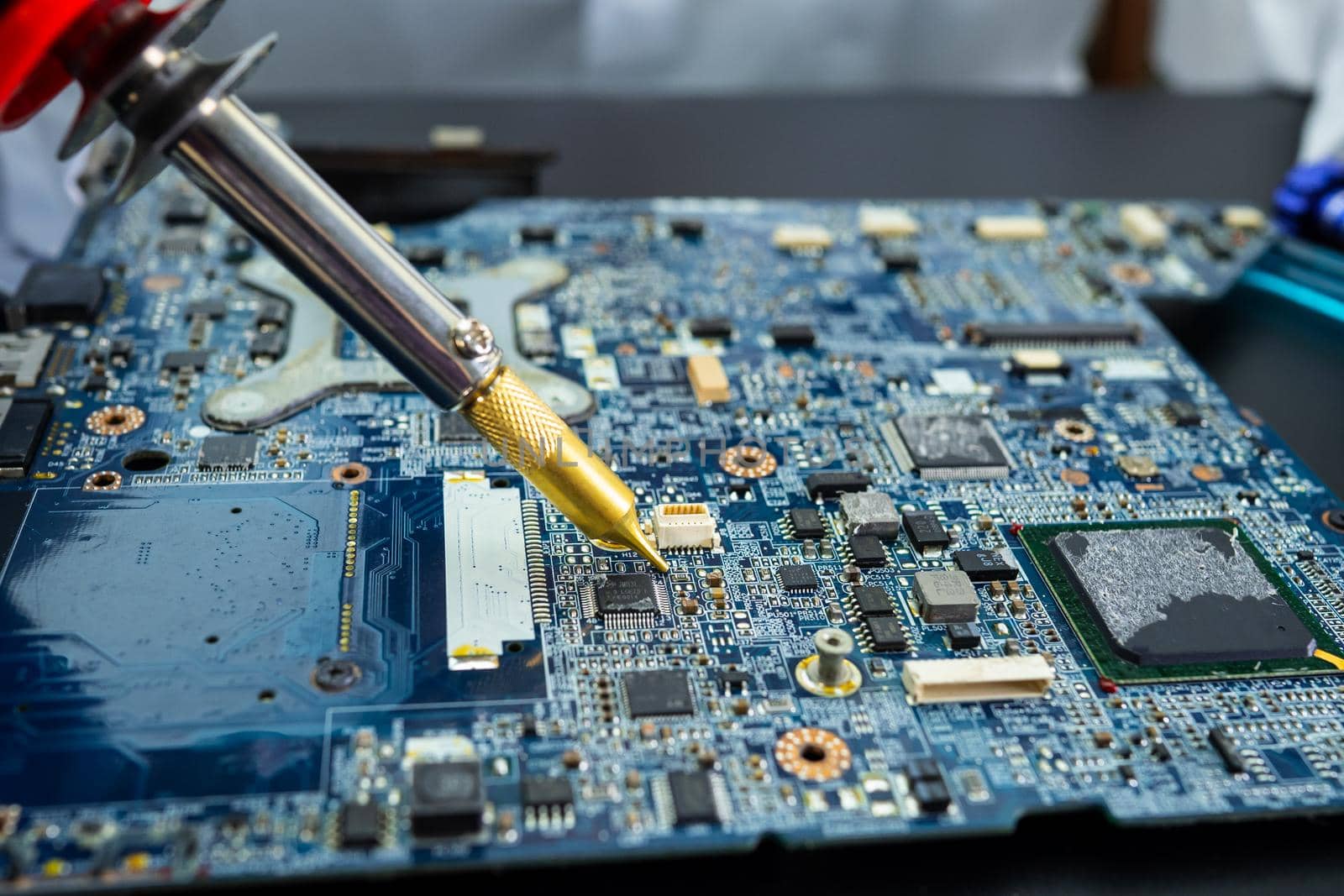 E-waste, technician repairing inside of hard disk by soldering iron. Integrated Circuit. the concept of data, hardware, technician and technology.