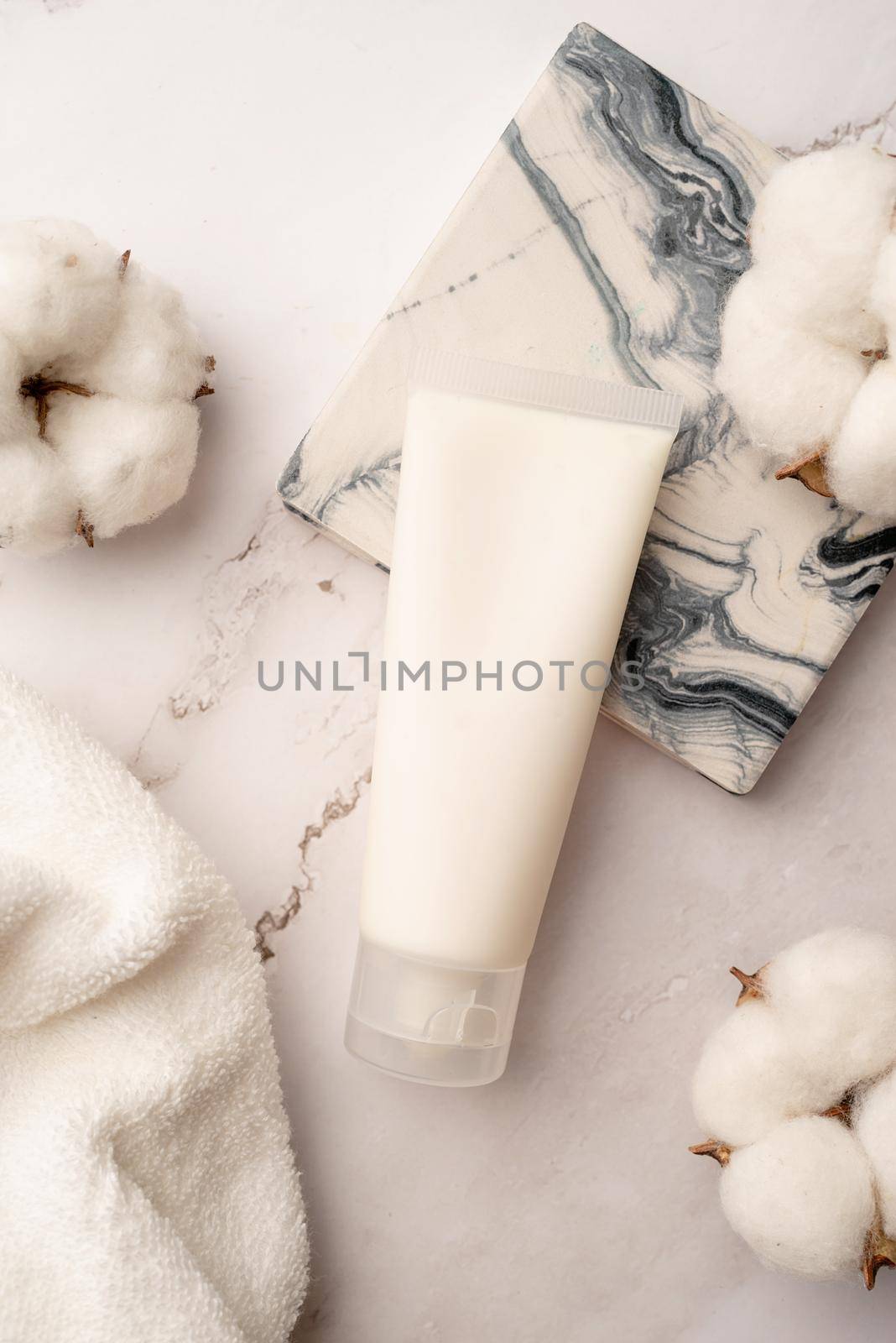 Mockup facial skincare product white tube with blank label on marble background, Top view