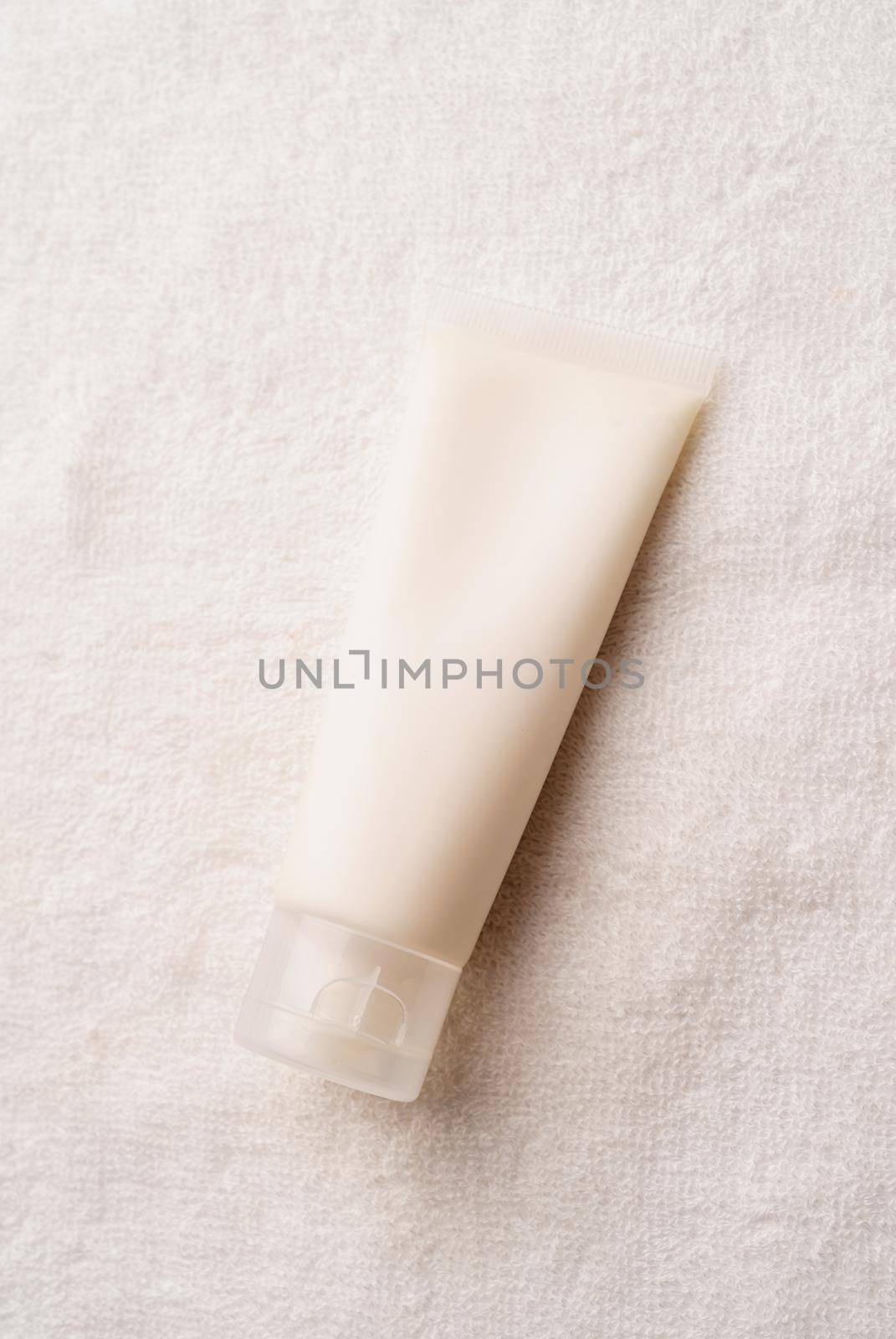 Mockup facial skincare product white tube with blank label on farbic background, Top view