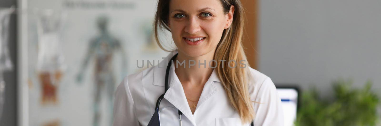 Young smiling female doctor holding clipboard closeup by kuprevich