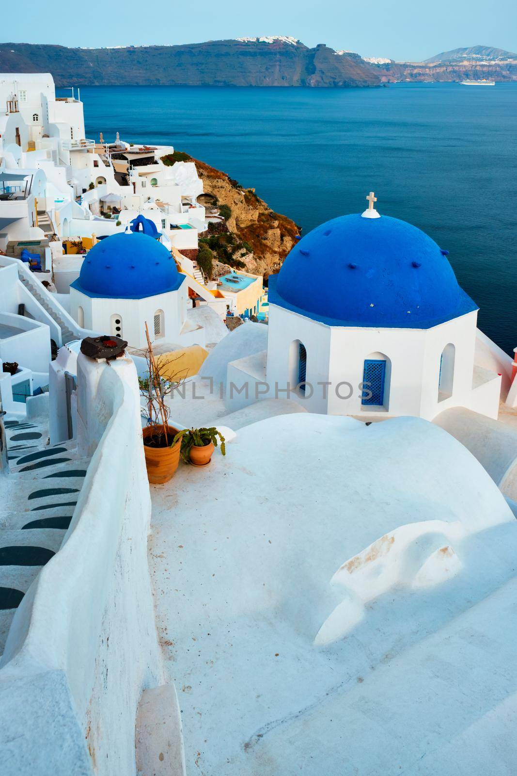 Famous view from viewpoint of Santorini Oia village with blue dome of greek orthodox Christian church by dimol