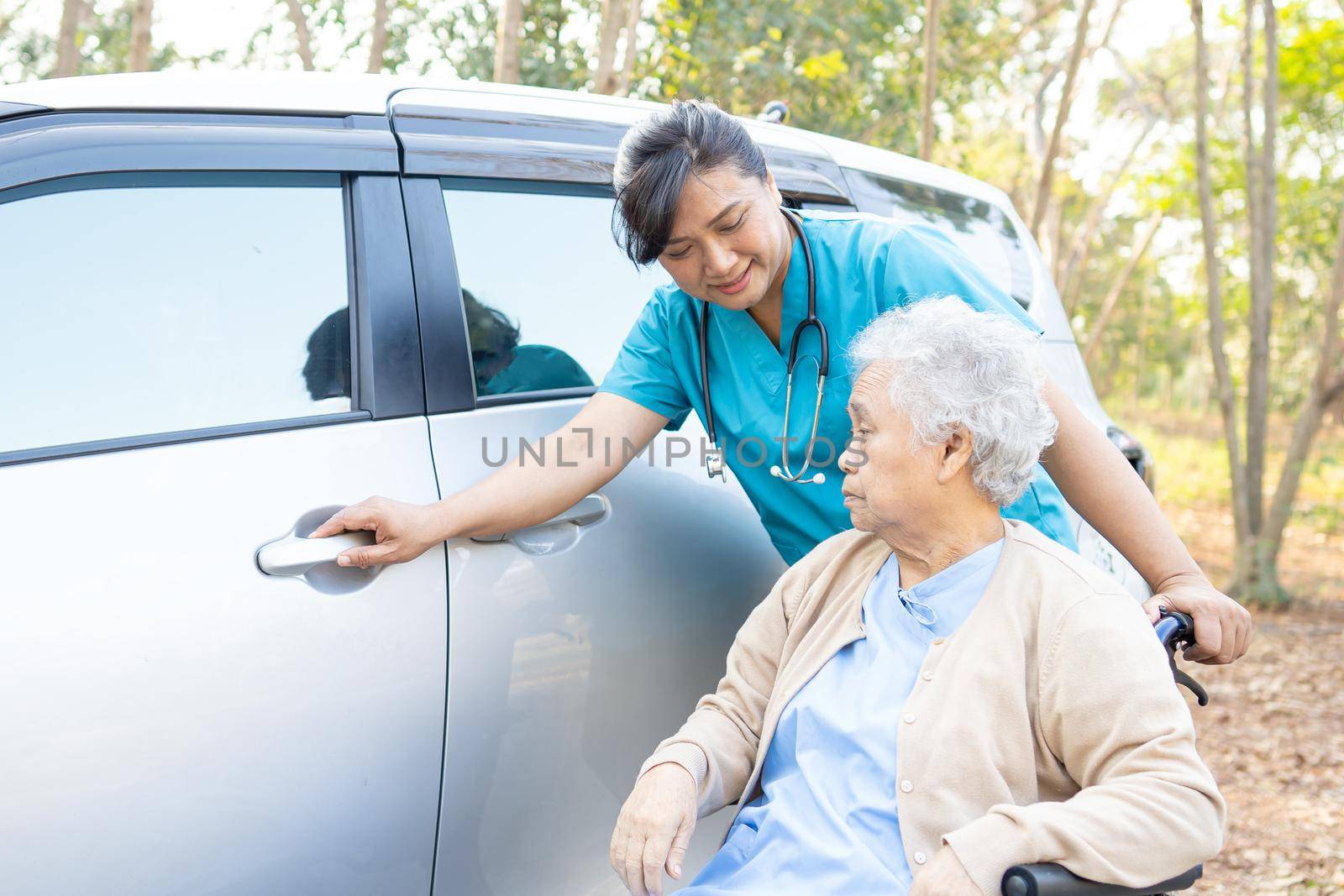 Help and support asian senior or elderly old lady woman patient sitting on wheelchair prepare get to her car, healthy strong medical concept. by pamai