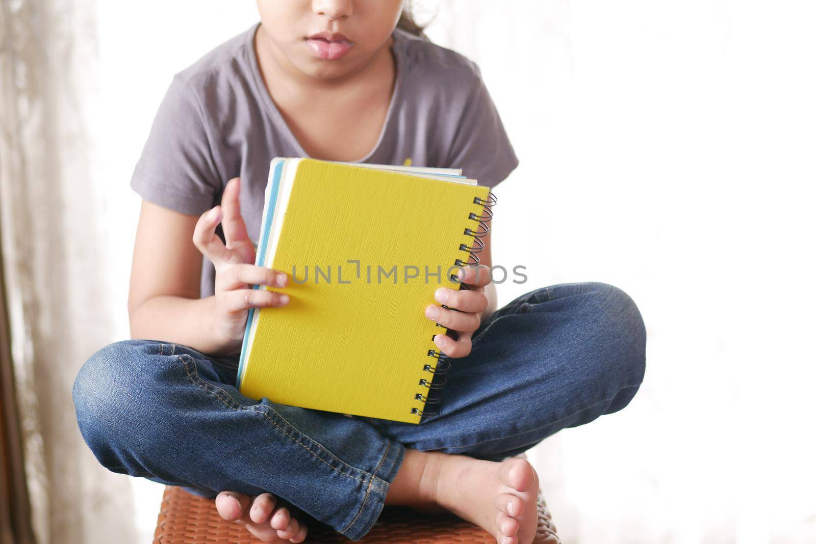 teenage child holding many colorful notepads .