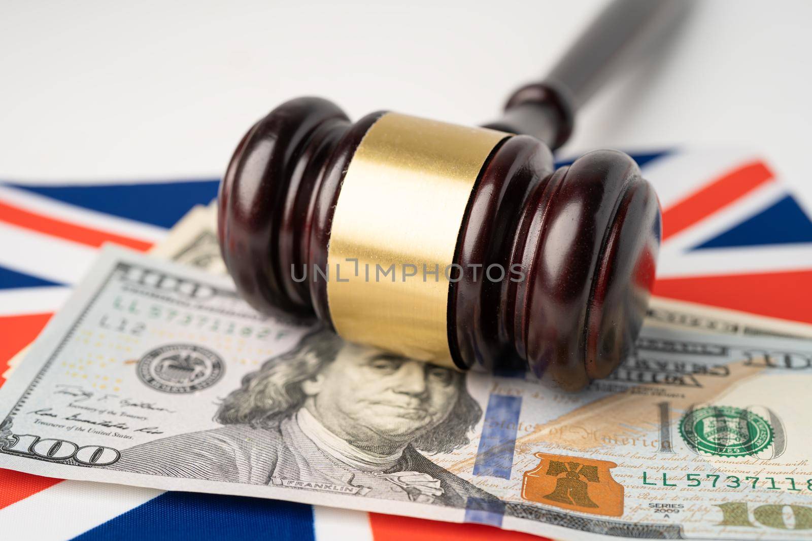 Gavel for judge lawyer and US dollar banknotes on England flag, finance concept. by pamai