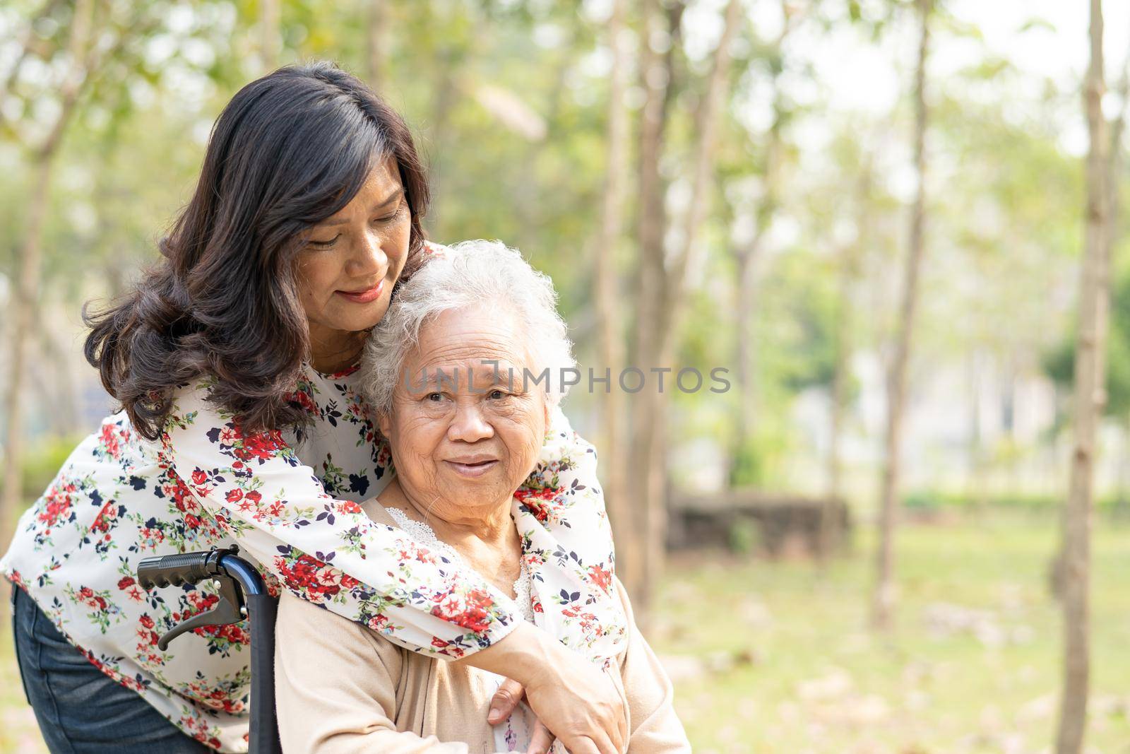 Asian senior or elderly old lady woman patient with care, help and support on wheelchair in park in holiday, healthy strong medical concept.