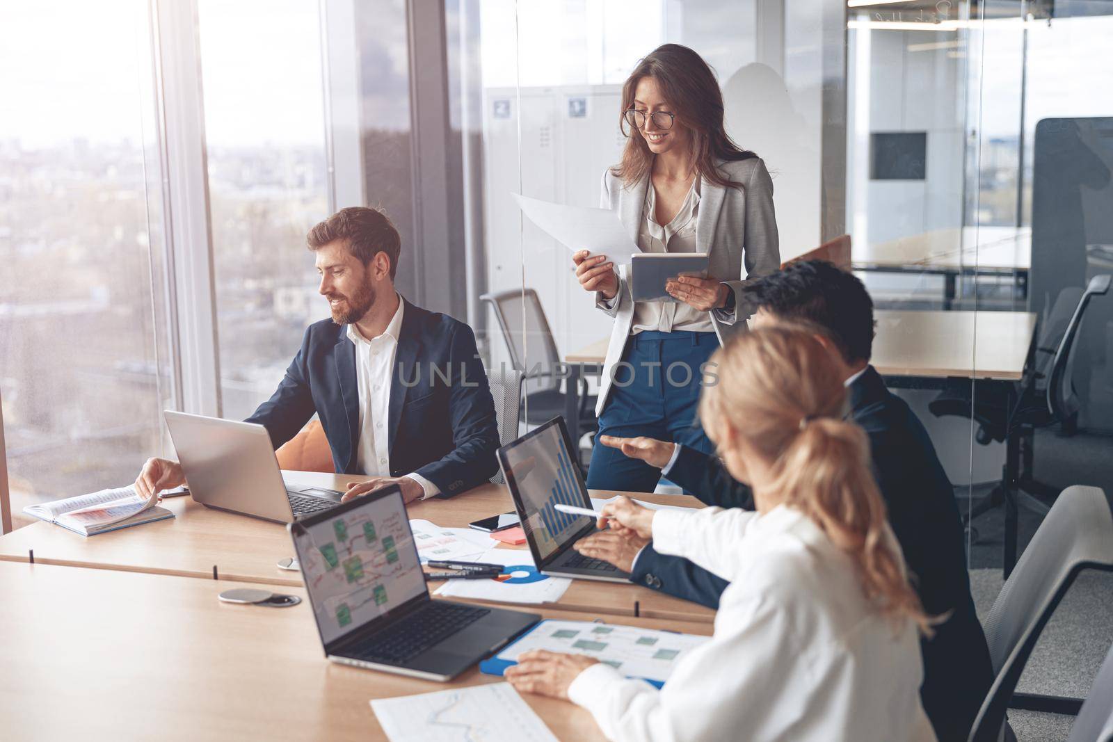 Young Businesspeople Working with Laptop in Modern Office. Discussion at Work Concepts.