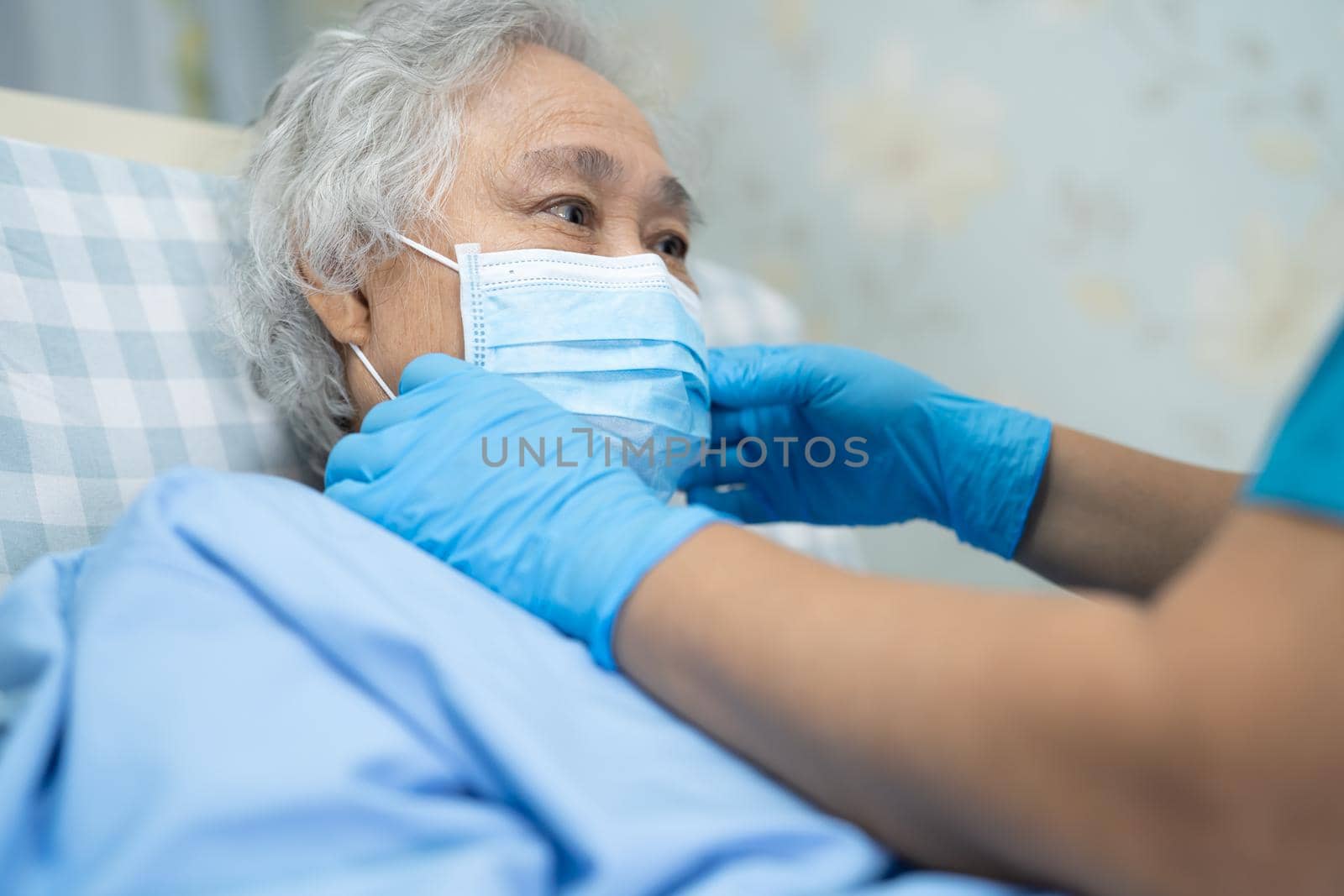 Asian senior or elderly old lady woman patient wearing a face mask new normal in hospital for protect safety infection Covid-19 Coronavirus.