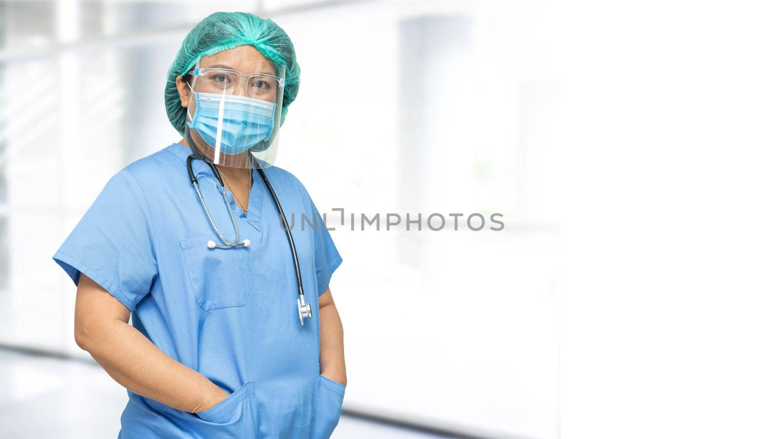 Asian doctor wearing face shield and PPE suit new normal to check patient protect safety infection Covid-19 Coronavirus outbreak at quarantine nursing hospital ward.