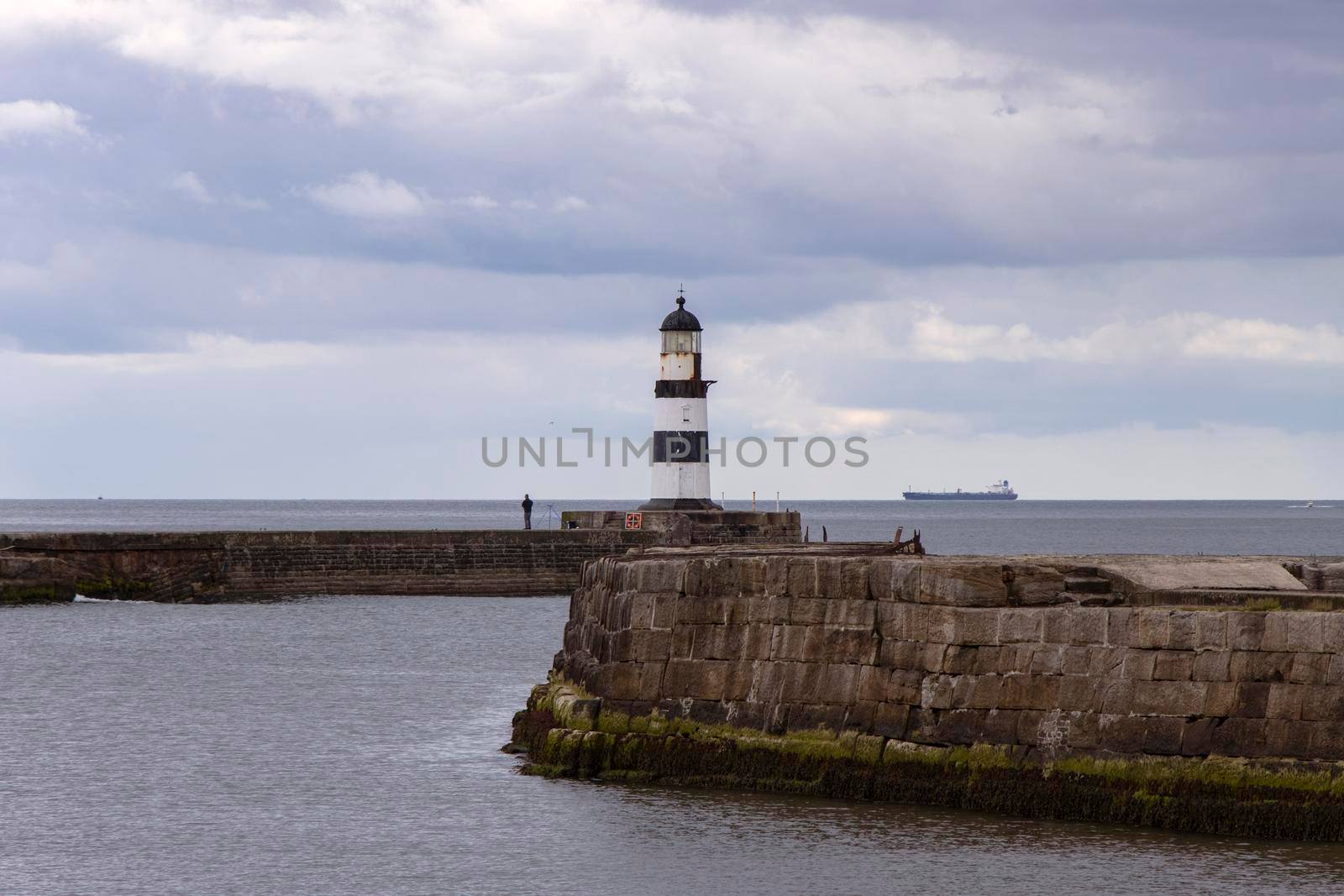 Iconic striped Seaham lighthouse on pier with clouds and sea walls by StefanMal