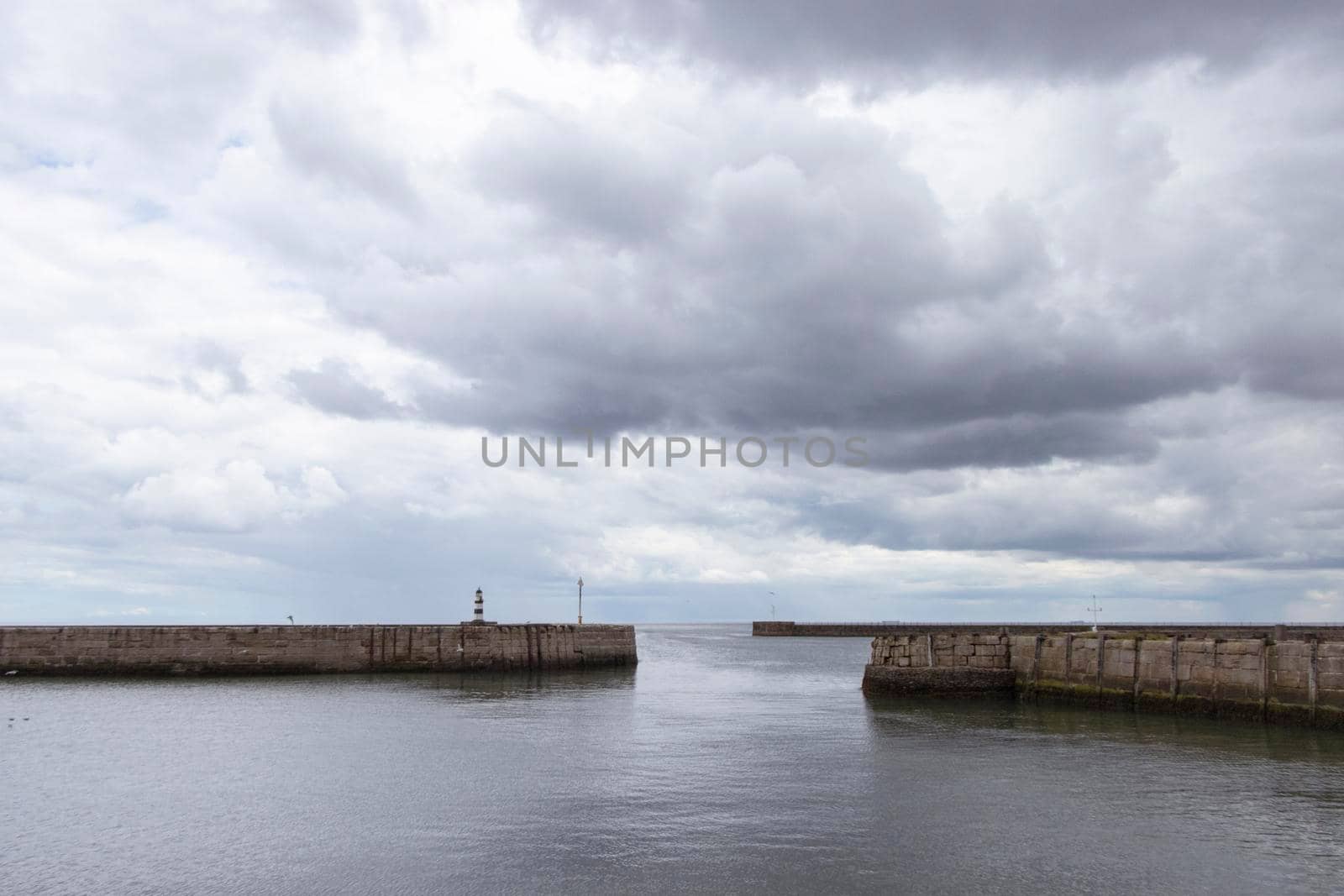 Iconic striped Seaham lighthouse on pier with clouds and sea walls by StefanMal