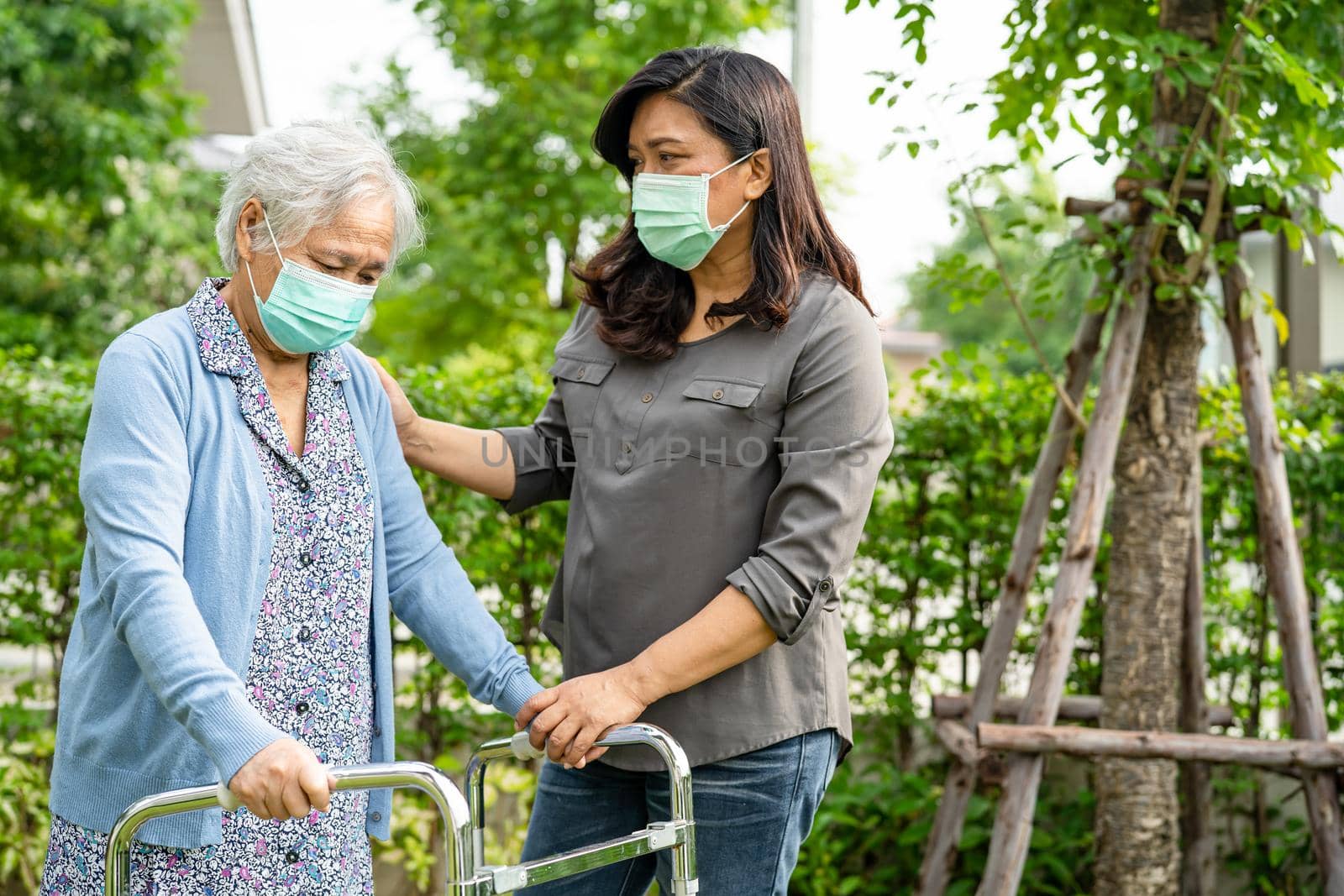 Asian senior or elderly old lady woman walk with walker and wearing a face mask for protect safety infection and kill Novel Coronavirus Covid-19 virus.