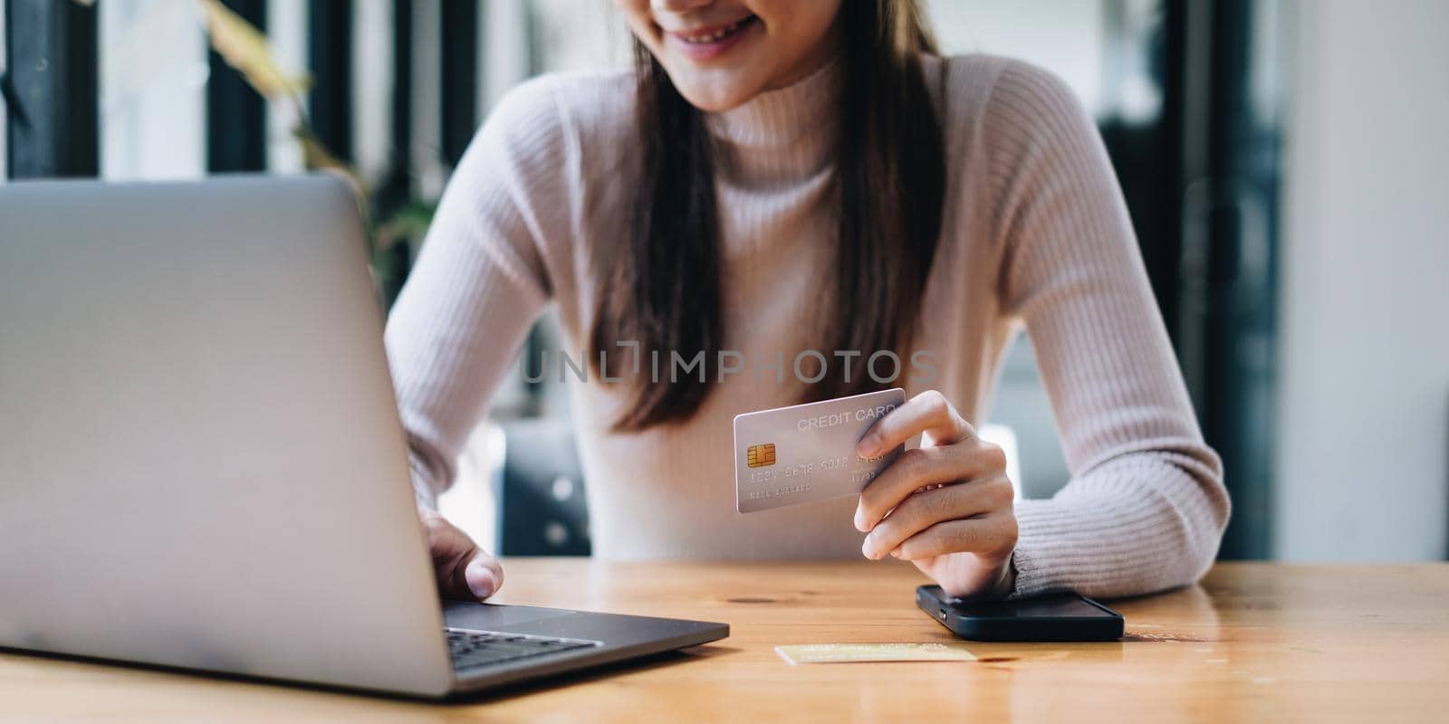 Woman using shopping web site by laptop computer and payment by credit card