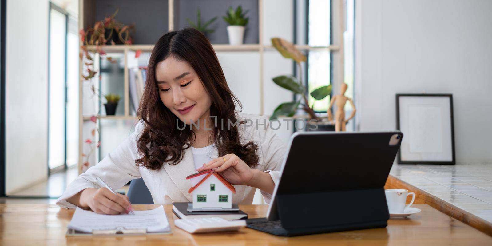 Close up of Business woman pointing and signing agreement for buying house. Bank manager concept