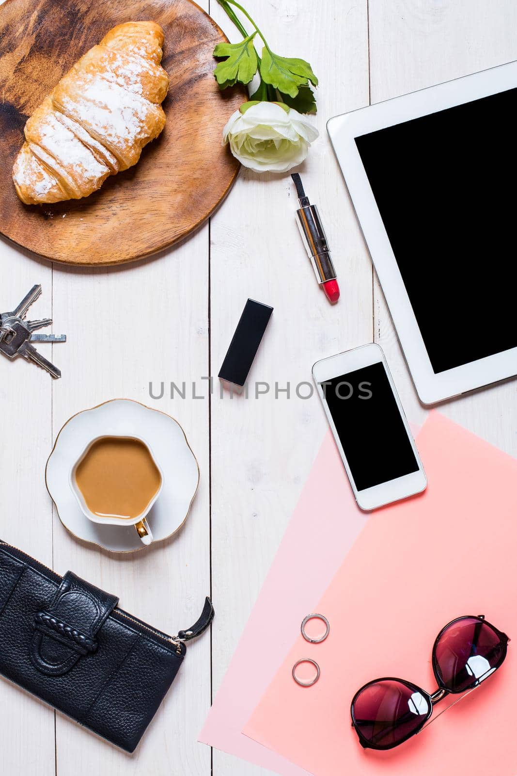 Flat lay, top view, mock up women's accessories on a white background. phone, croissant, a cup of coffee