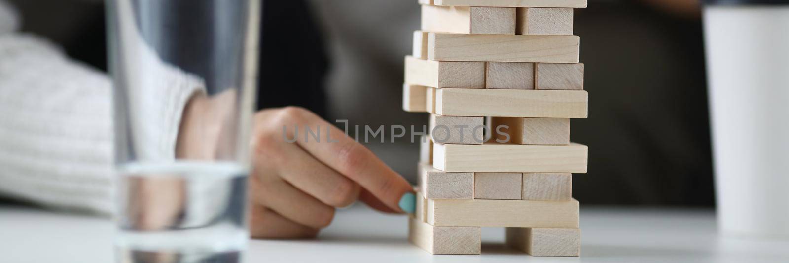 Two players take turns removing wooden blocks from tower. Family board games concept