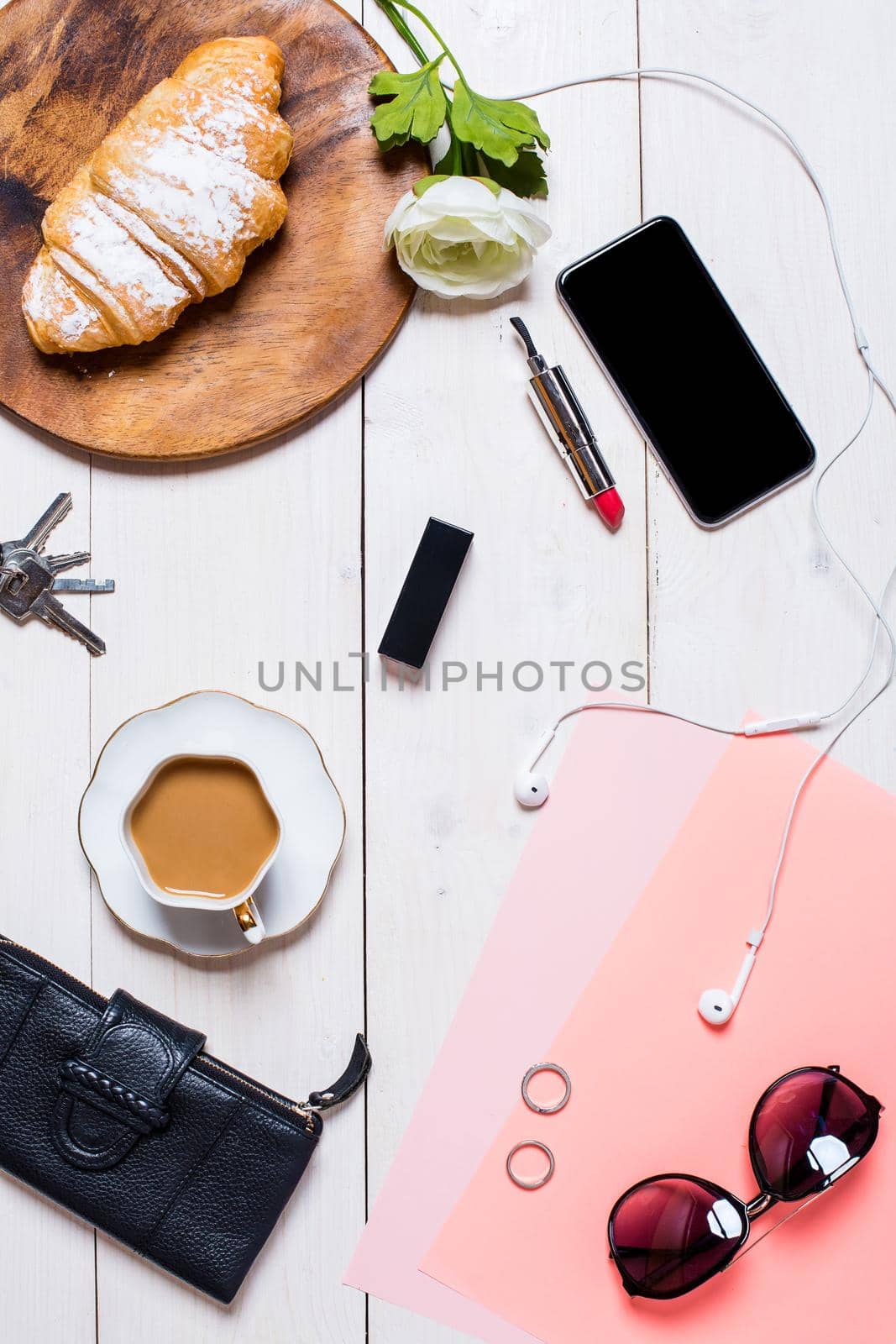 Flat lay, top view, mock up women's accessories on a white background. phone, croissant, a cup of coffee