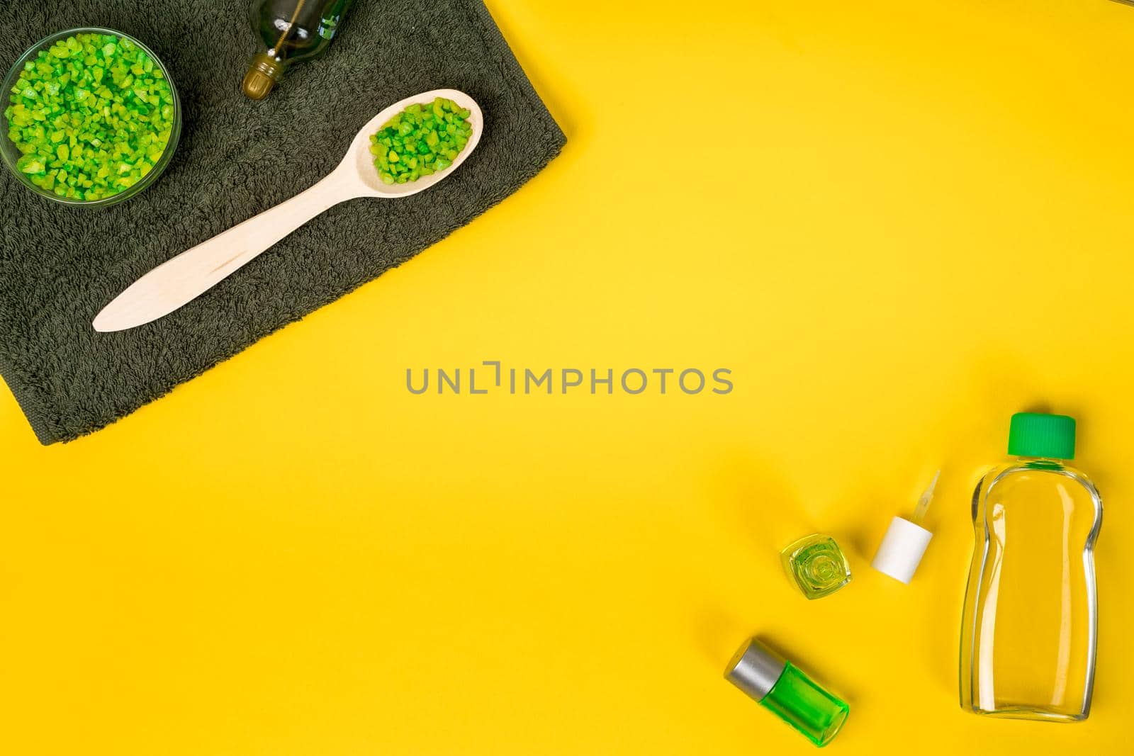 Spa set: soap, mask, oil, sea salt and towel on yellow background. Top view. Still life. Copy space