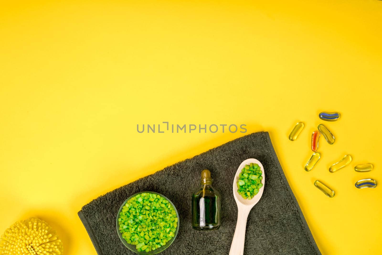 Spa set: soap, mask, oil, sea salt and towel on yellow background. Top view. Still life. Copy space