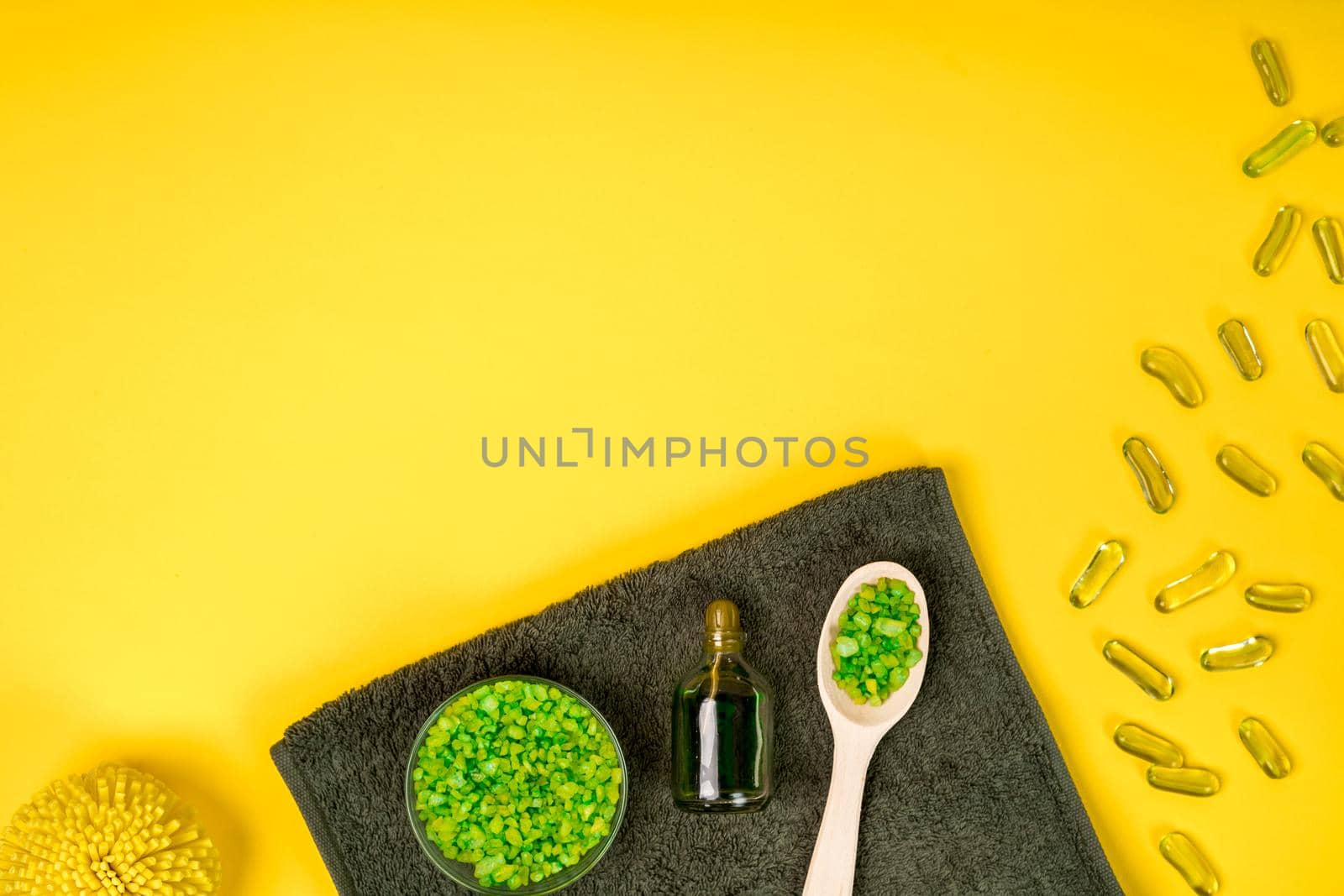 Spa set: soap, mask, oil, sea salt and towel on yellow background. Top view. Still life. Copy space