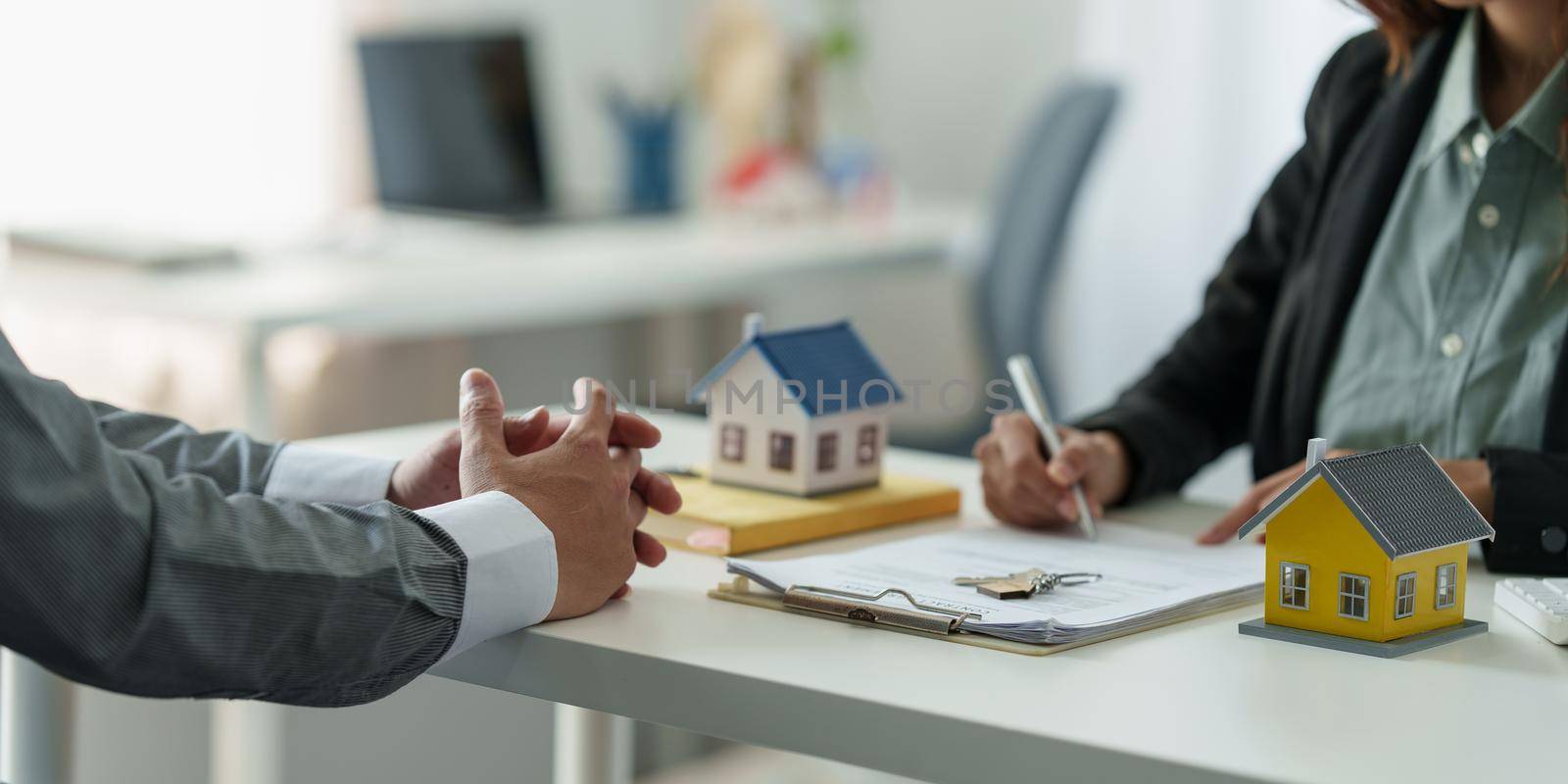 Close up Business woman or agent checking agreement contract before giving house for buying house. Bank manager and real estate concept