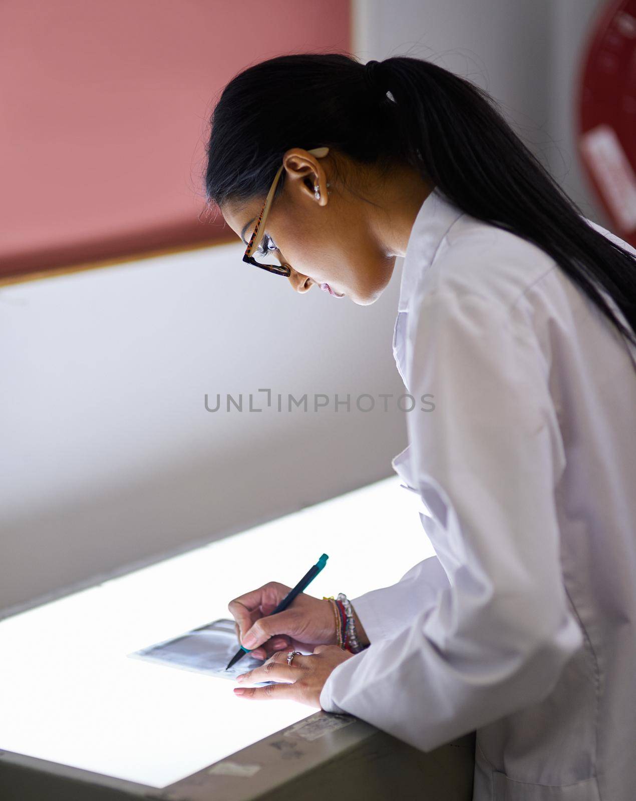 Working on a suitable treatment for the dental problem. Cropped shot of a young female dentist analysing an x-ray. by YuriArcurs
