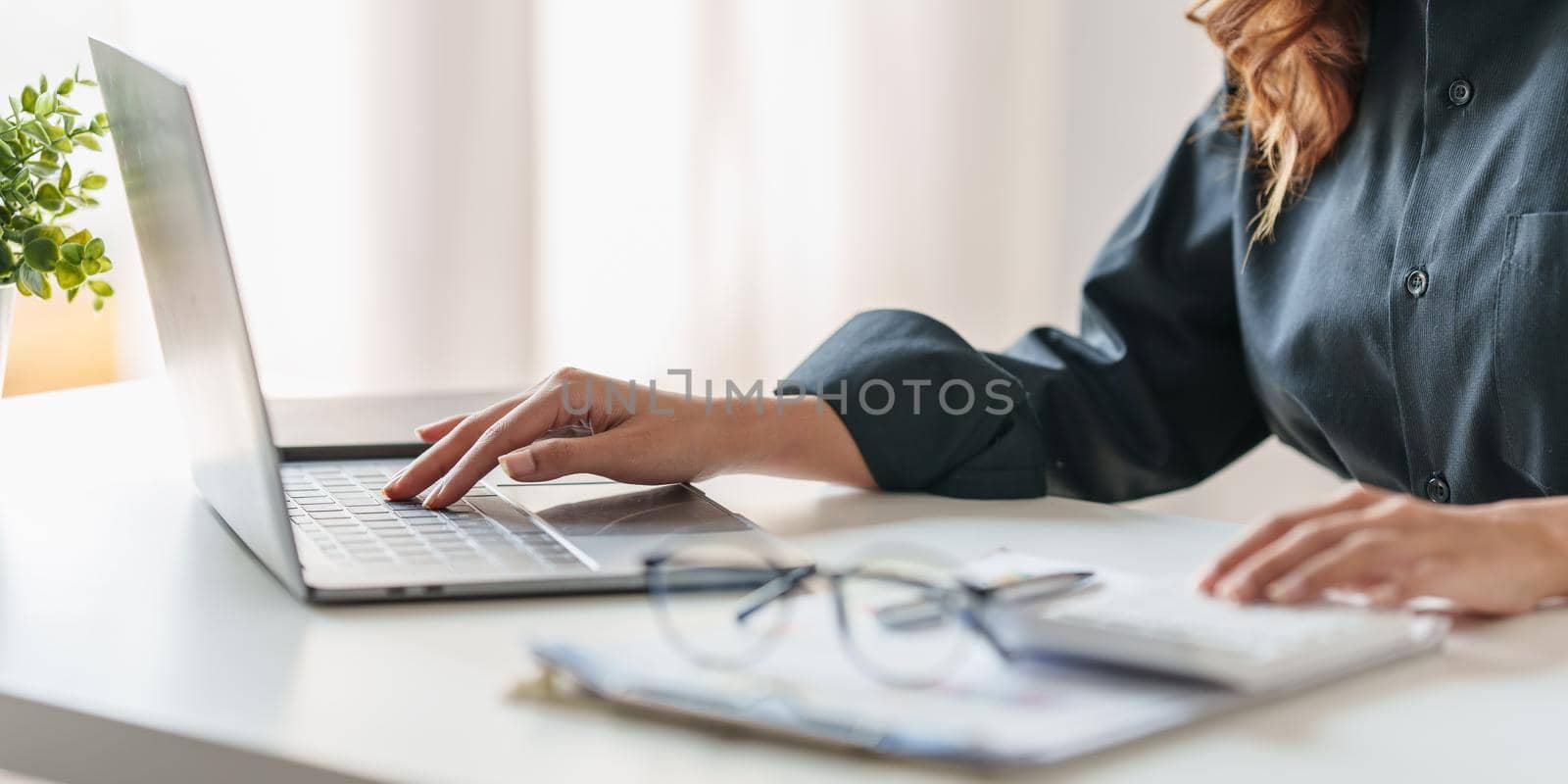 Close up Business woman hand using calculator to calculate on laptop the company's financial results and budget. Account Audit Concept