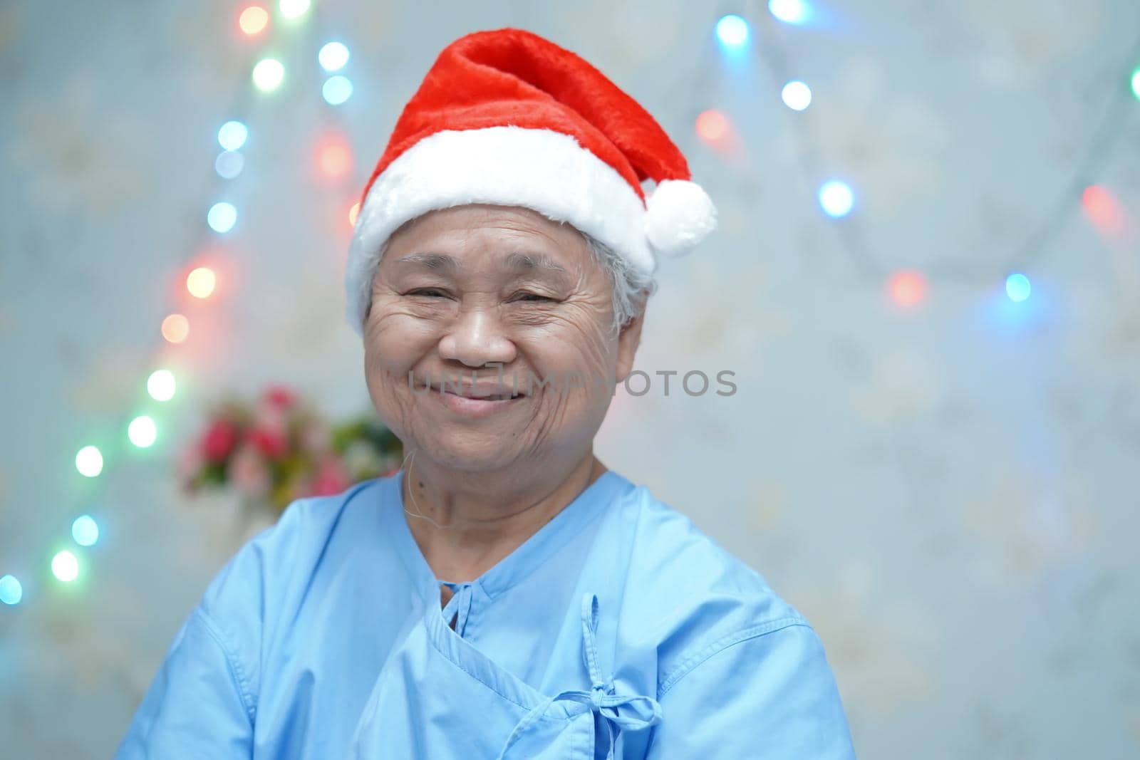 Asian senior or elderly old lady woman patient with Santa Claus helper hat very happy in Christmas and new year celebration festival holiday party in hospital.