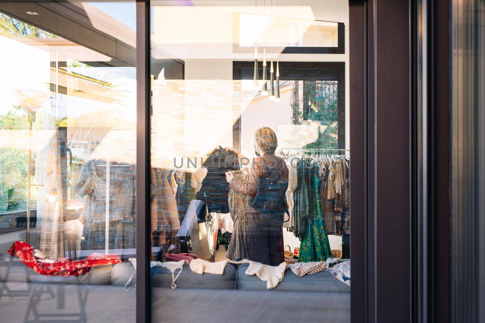 view from outside of two women inside a clothes shop. shop window, shopping concept. by CatPhotography