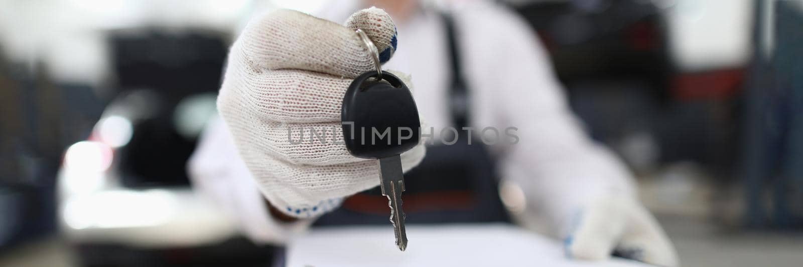 Car service employee holds keys in hand and clipboard. Mechanic is welcome to work concept