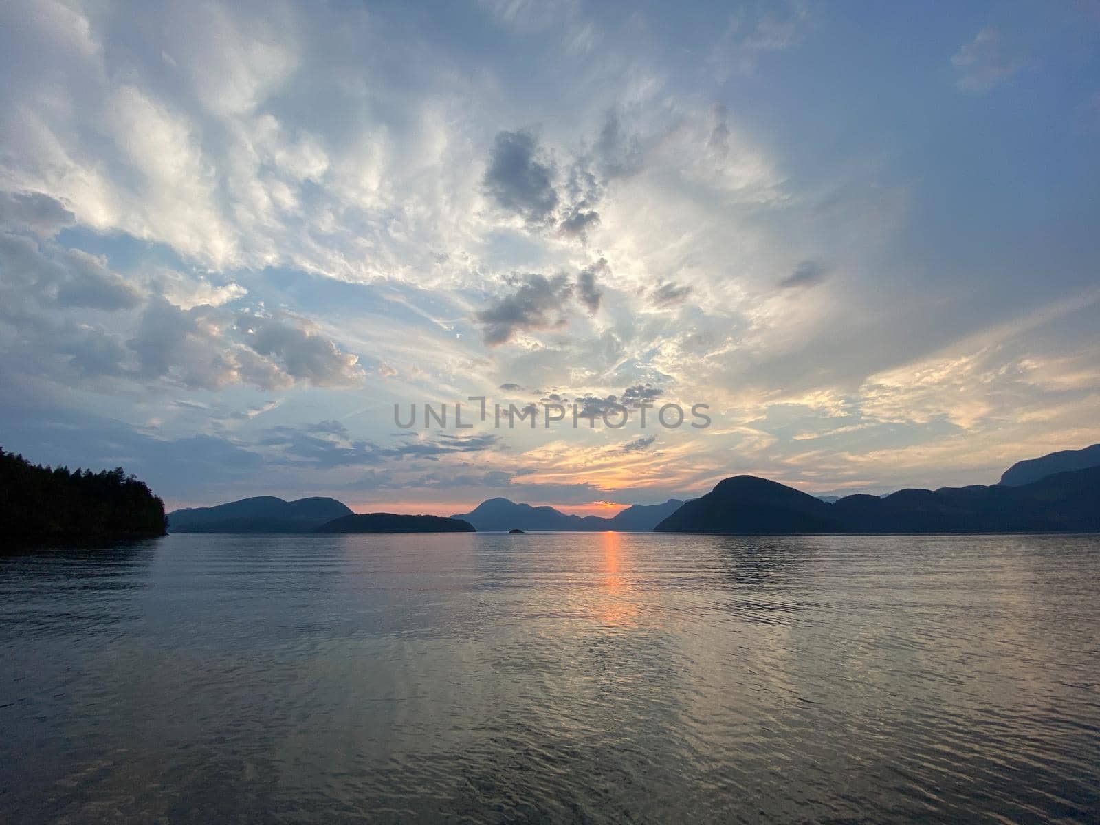 Sunset scene over mountains with reflection on water, near Thetis Island, Vancouver Island, British Columbia, Canada