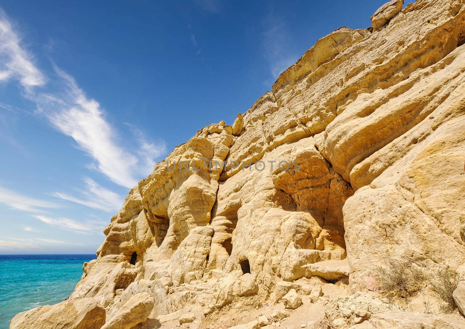 Matala beach with caves on the rocks that were used as a roman cemetery and at the decade of 70's