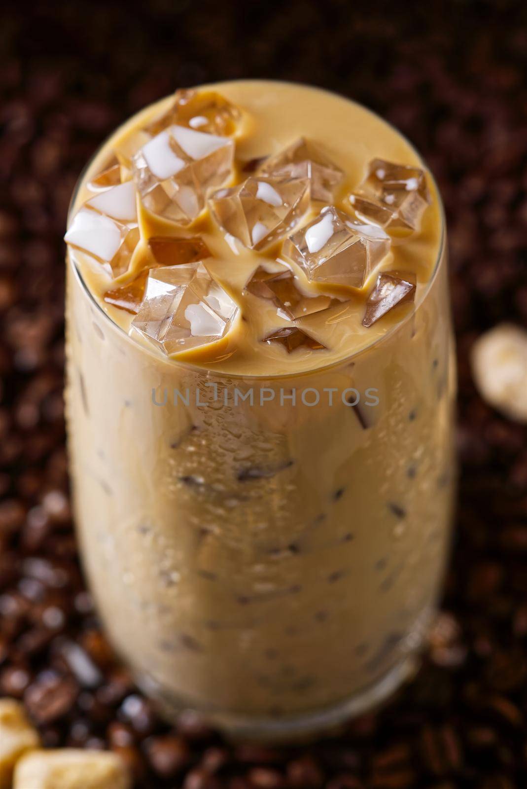 Iced latte coffee. Cup of Iced latte coffee, milk tea on dark coffee seeds background by PhotoTime