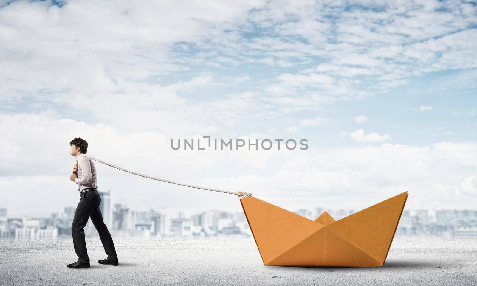 Successful businessman pulling with rope paper boat