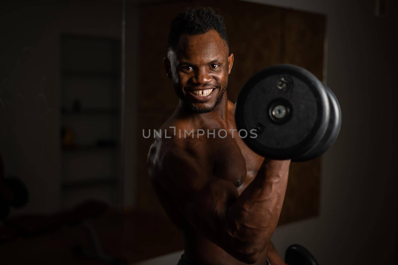 Attractive african american man smiling and doing exercise with dumbbells. by mrwed54