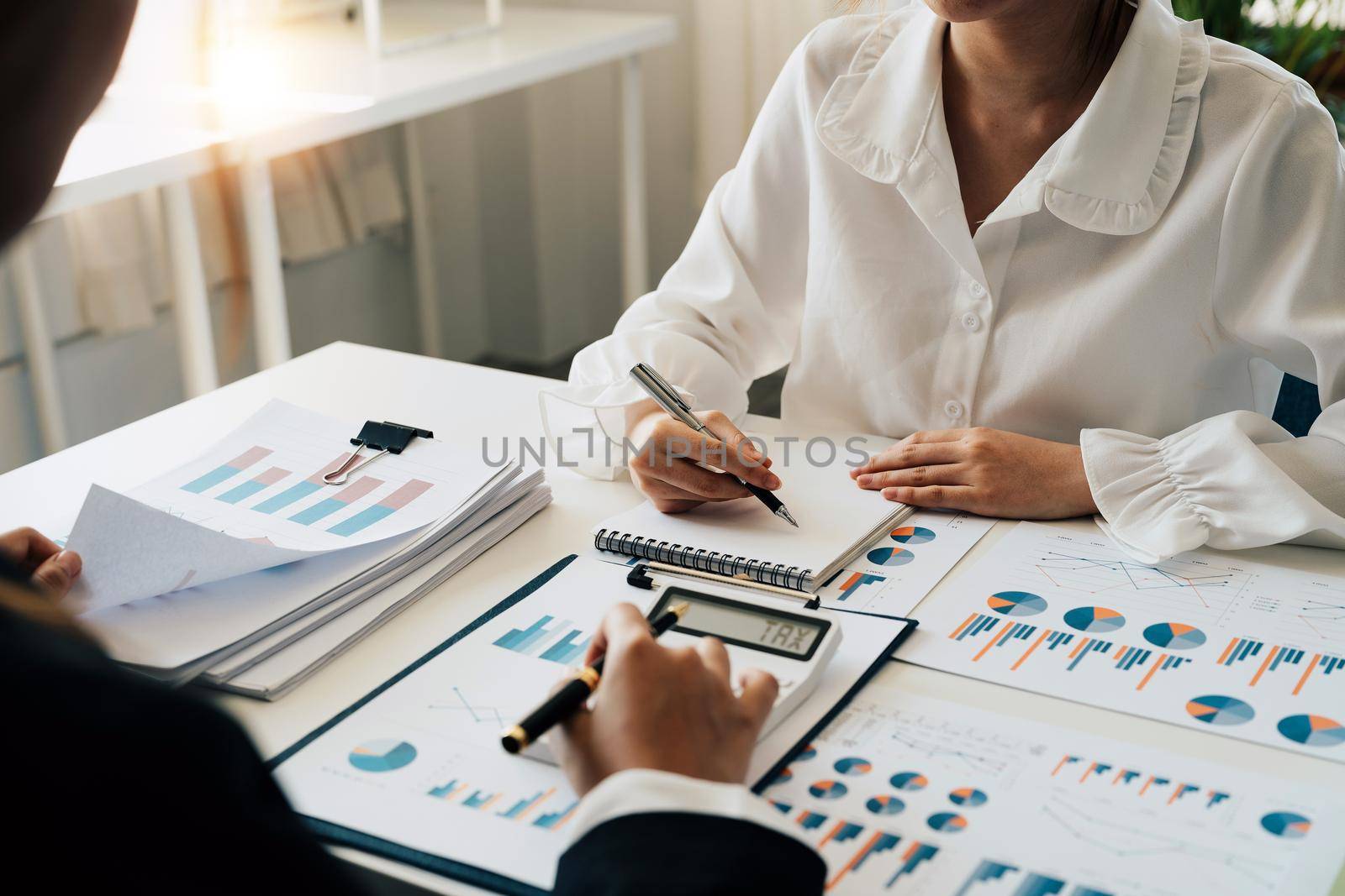 Financial adviser working with client, calculating and analyzing data paperwork chart for meeting team in office room. concept finance and accounting by nateemee